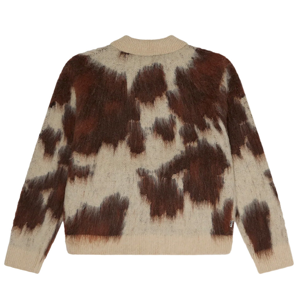 Back flat lay view of the Obey Cow Pattern Zip Sweater, highlighting the continuous brushed knit texture and abstract cow print spots across the shoulders and lower back, with a solid ribbed hem, ribbed collar edge, and a discreet woven OBEY flag label sewn into the lower right side seam.