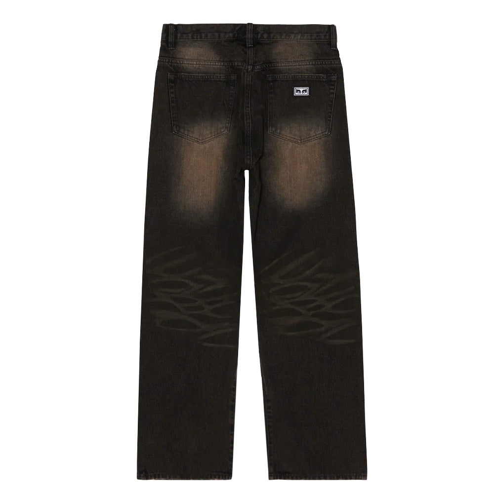 Back flat lay view of the Obey Studded Boxcar Straight Leg Denim in black rust wash, highlighting the roomy seat with rust-tone fading down the upper thighs, subtle tone-on-tone graffiti-style line art graphics across the back of the knees, deep back patch pockets, and a small rectangular Obey Eyes logo patch on the right back pocket.