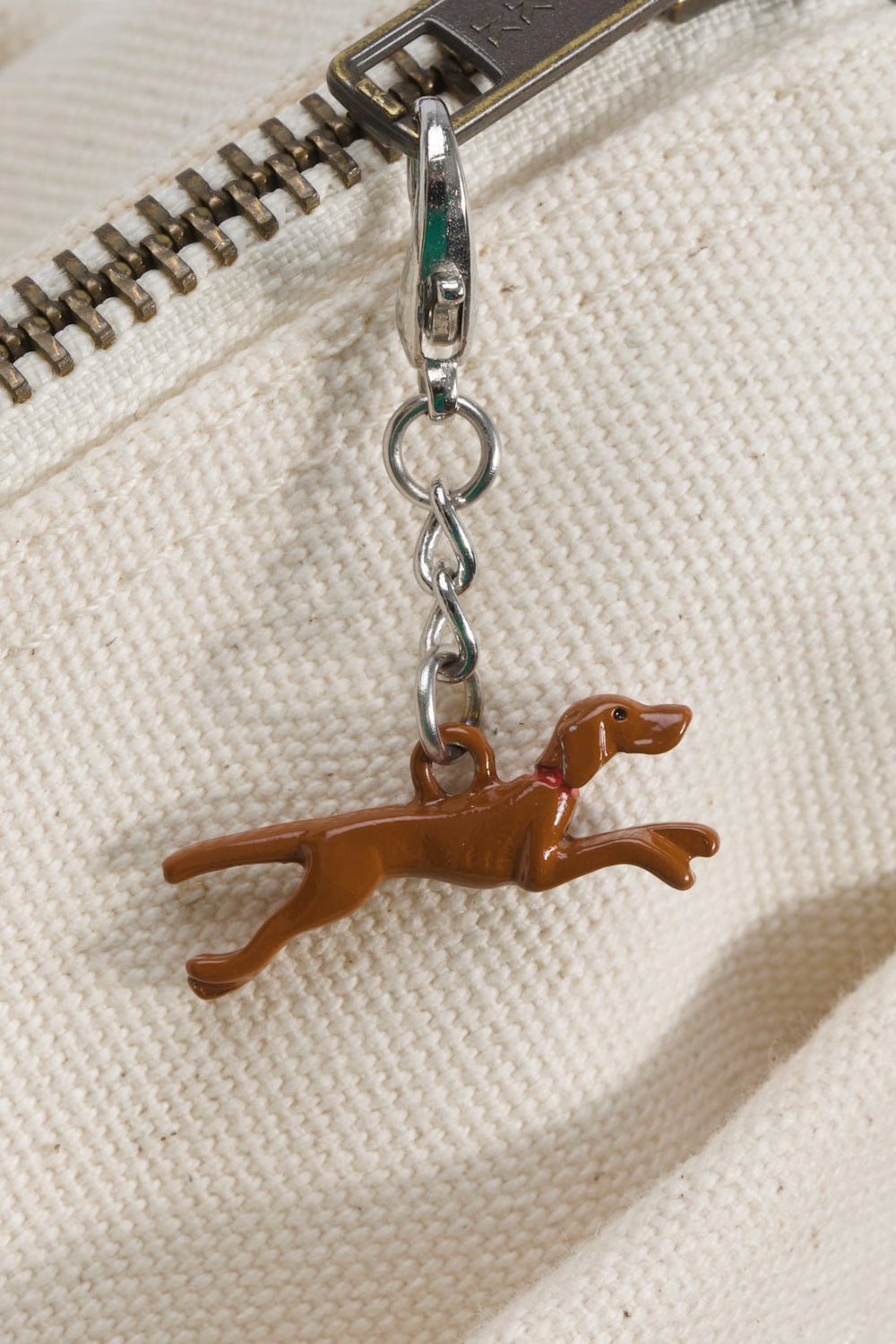 Close-up of YKK zipper on OTW by Vans x Julian Klincewicz tote bag with signature Roo dog charm, natural canvas texture and premium hardware detailing
