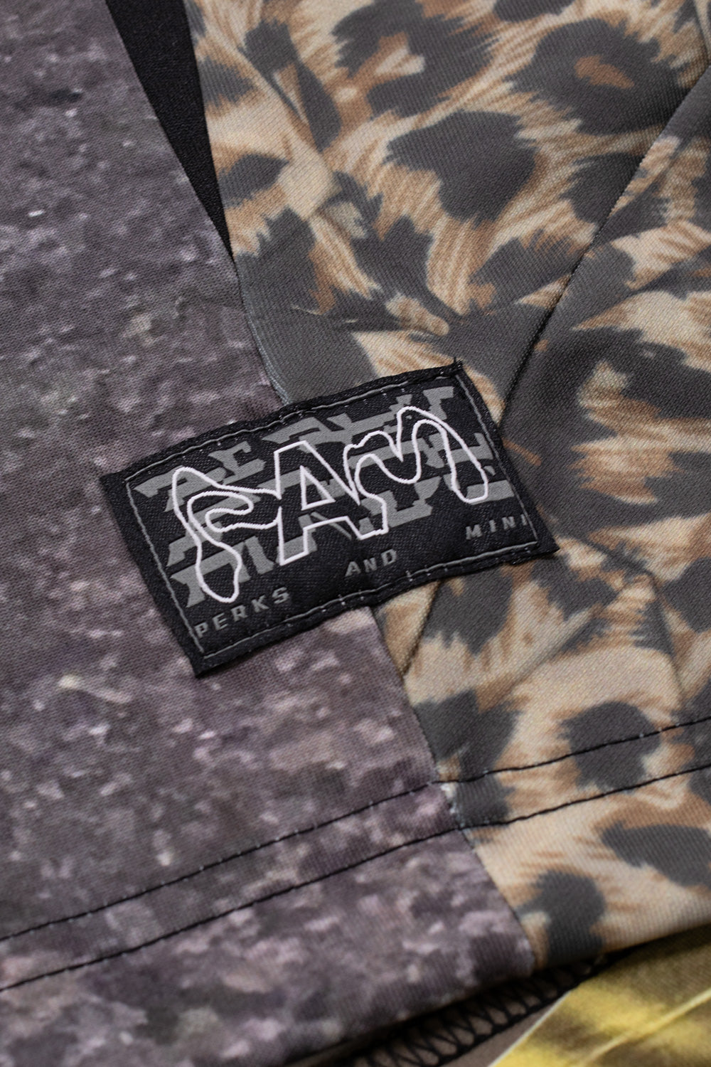 "Nahaufnahme des Allover-Print-Stoffs des Perks and Mini Sativa FC Jerseys in Braun"