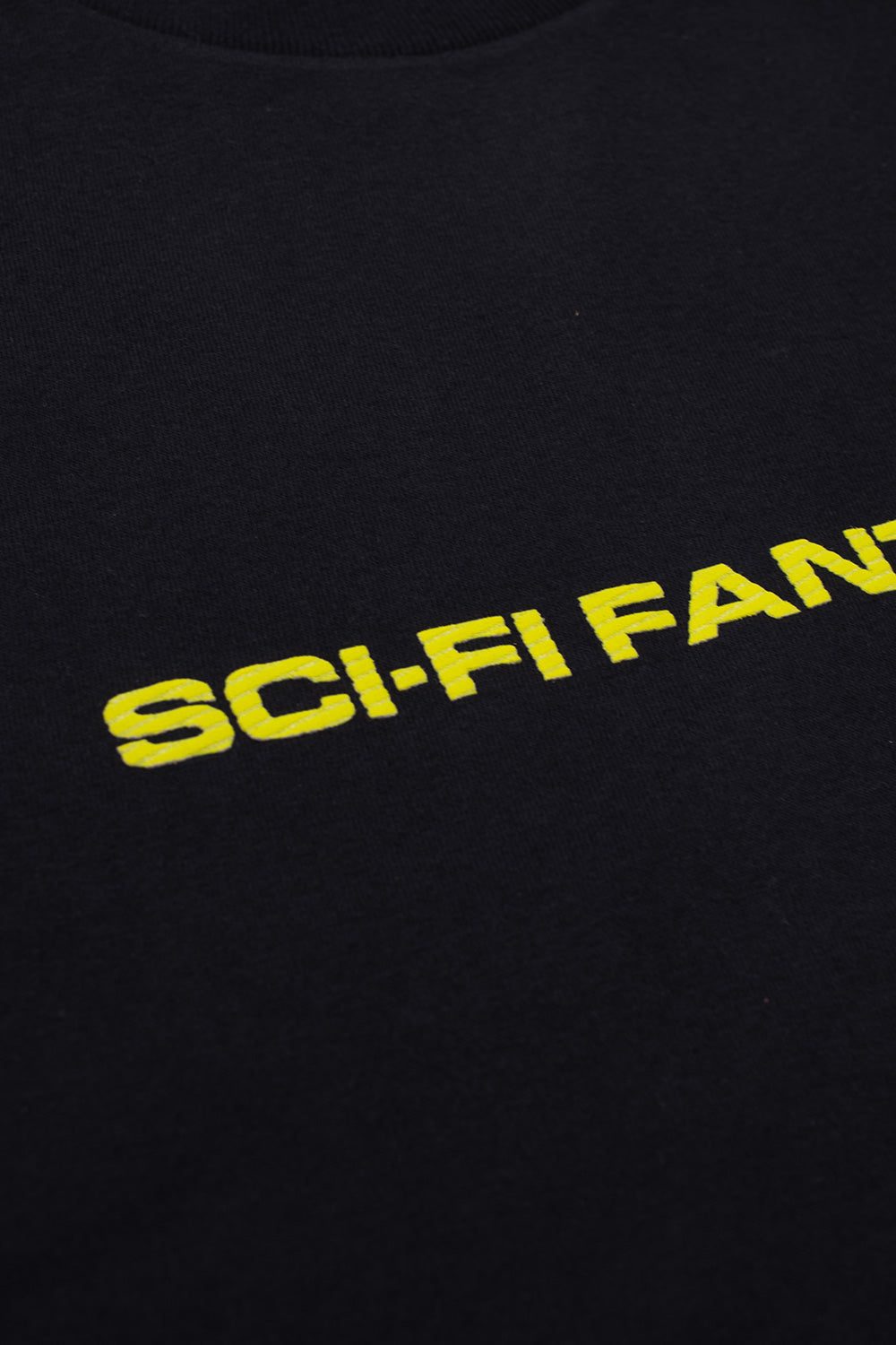 Detailaufnahme des strukturierten Sci-Fi Fantasy Logos auf der Vorderseite des schwarzen T-Shirts