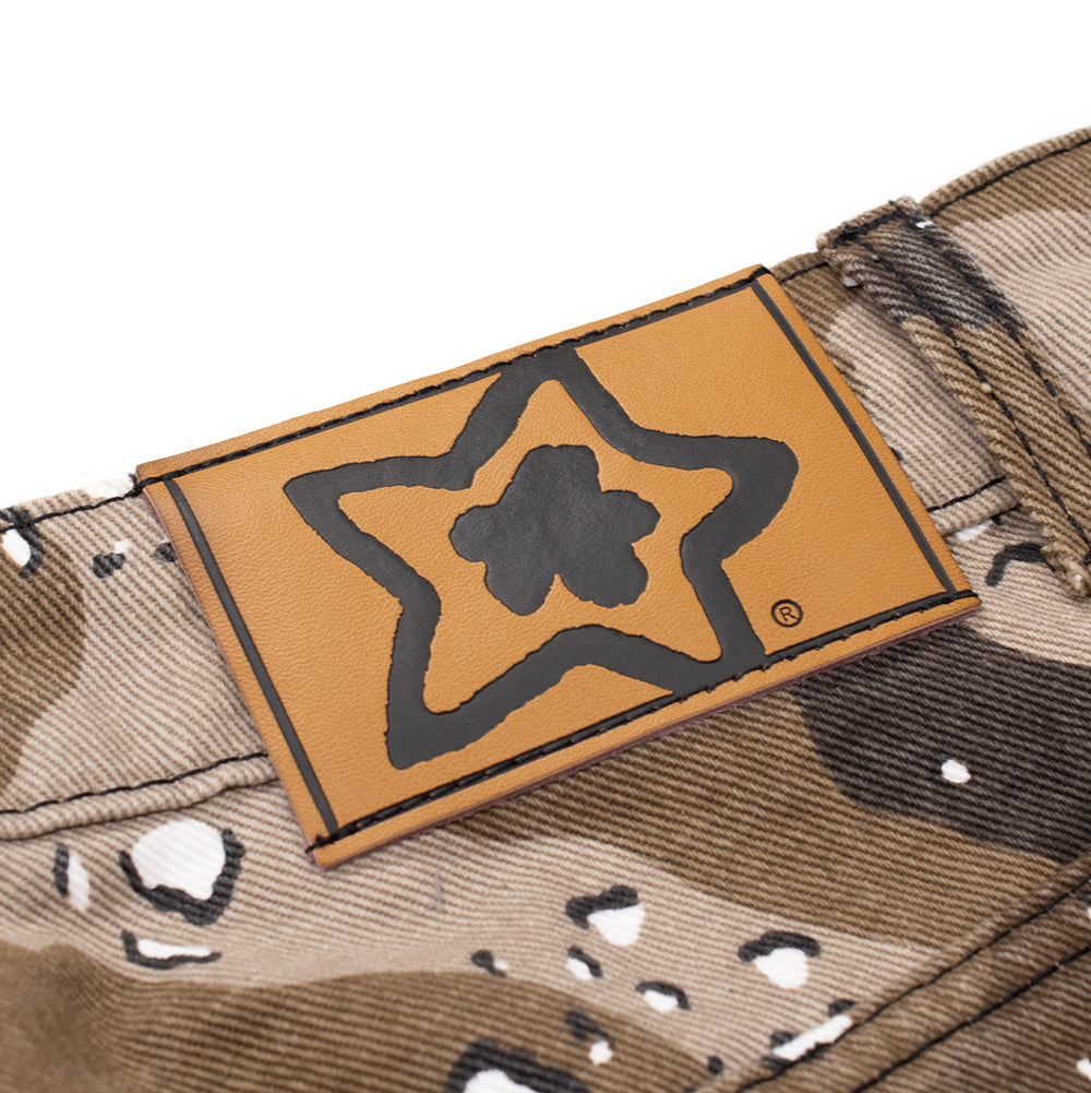 Macro studio view of the rear waistband on the Starteam East Village Chocolate Chip Camo Star Jeans, detailing the light caramel brown faux-leather jacron patch debossed with black Starteam logo artwork and registered trademark symbol sewn securely across the upper waist hem.