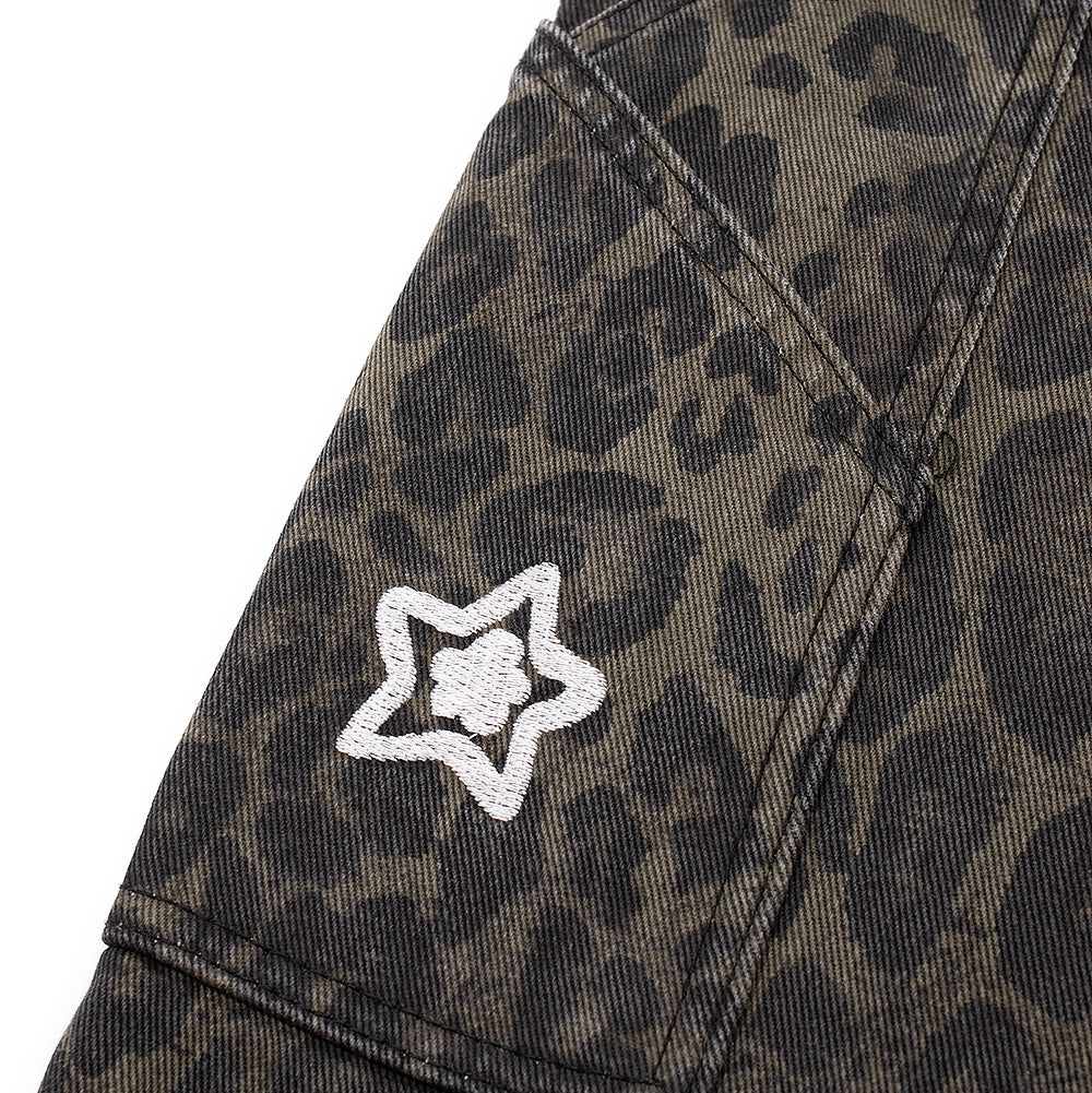 Detailed perspective of the right outer thigh carpenter tool pocket on the Starteam Leopard Star Jeans, featuring an angled top entry edge, heavy-duty utility seam construction, and a miniature white embroidered Starteam flower-star icon positioned centrally over the faded animal print canvas.