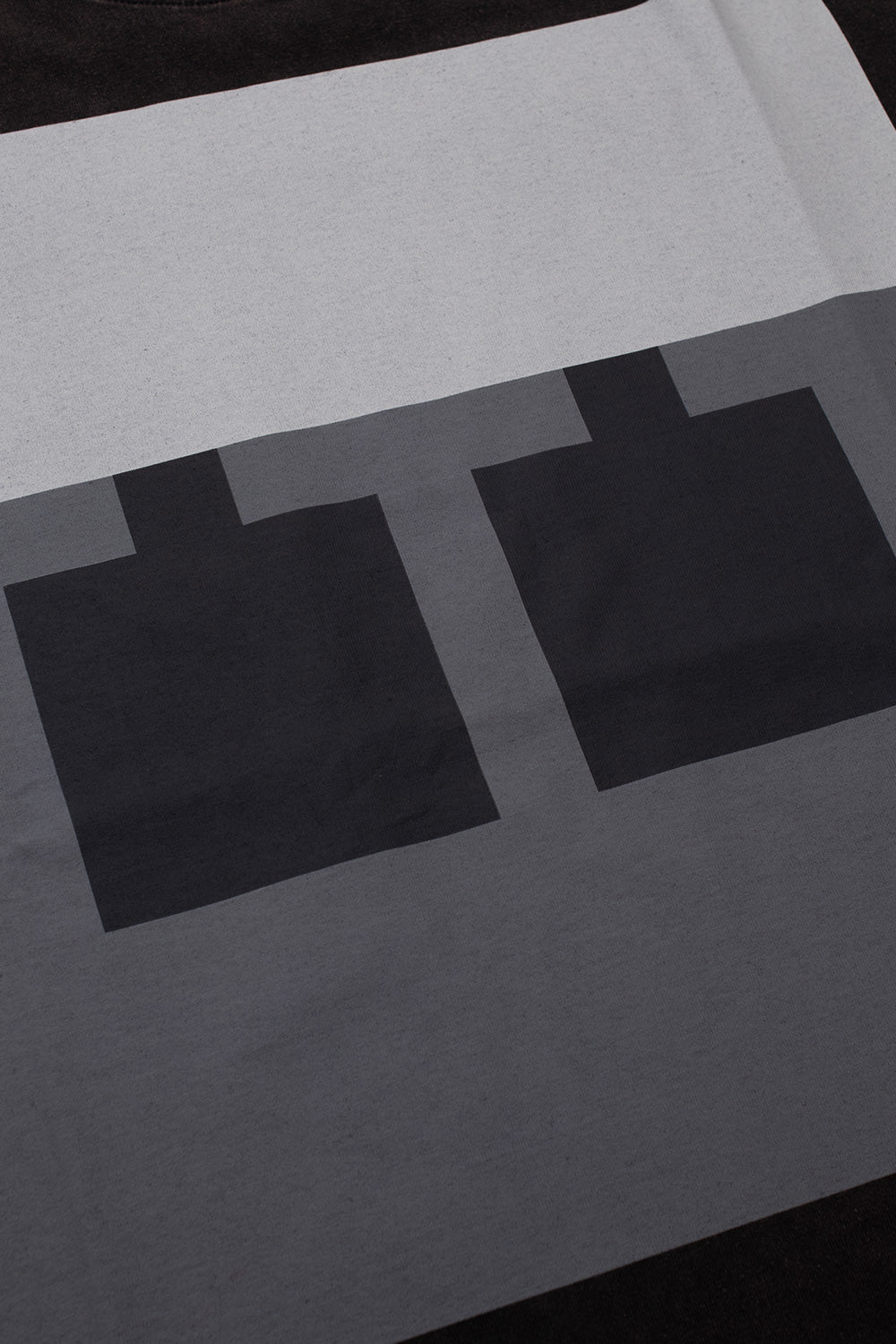 Close-up of the oversized Block front print on the The Trilogy Tapes Block T-Shirt Black Acid Wash, highlighting the minimalist geometric artwork, premium screen print, heavyweight cotton jersey, washed black fabric and contemporary experimental streetwear aesthetic inspired by underground techno culture.