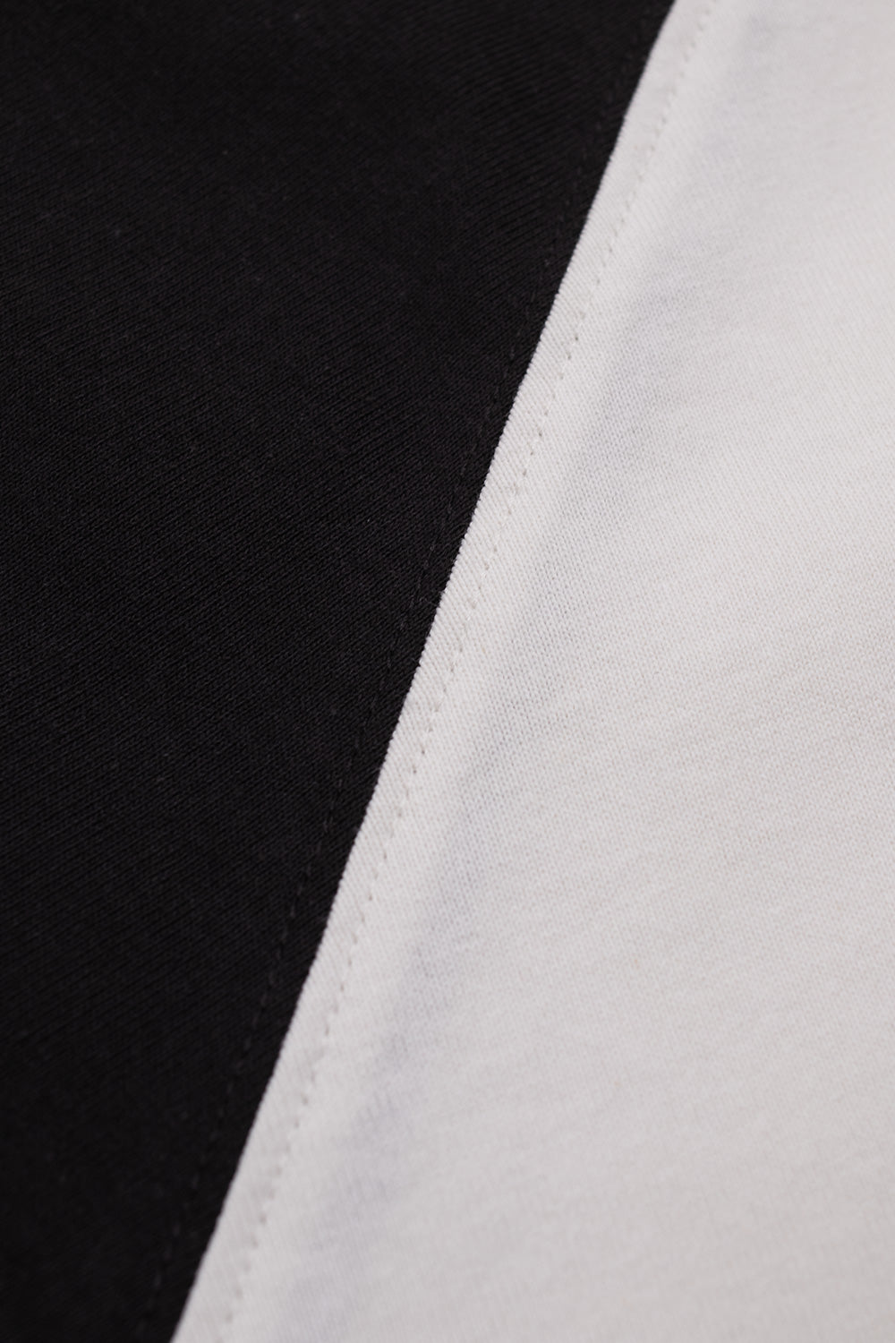 Detailed fabric view of the The Trilogy Tapes Siberian Girl Raglan T-shirt highlighting the premium heavyweight cotton jersey, contrasting black raglan sleeves, clean stitching, durable construction and high-quality streetwear craftsmanship in Black White.