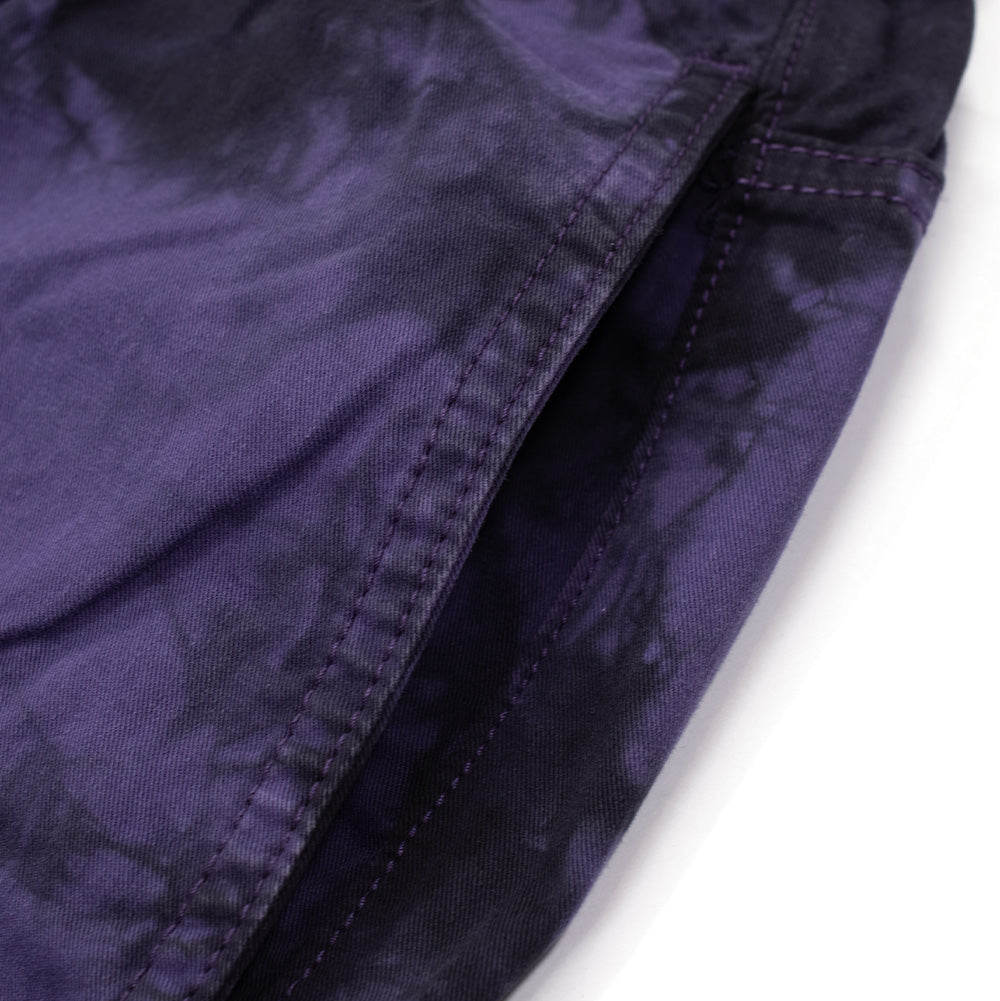 Detailed close-up shot of the side seam and slanted front hand pocket opening on the Token Sundown Pants, displaying the deep purple and dark black tie-dye dye wash and reinforced topstitching.