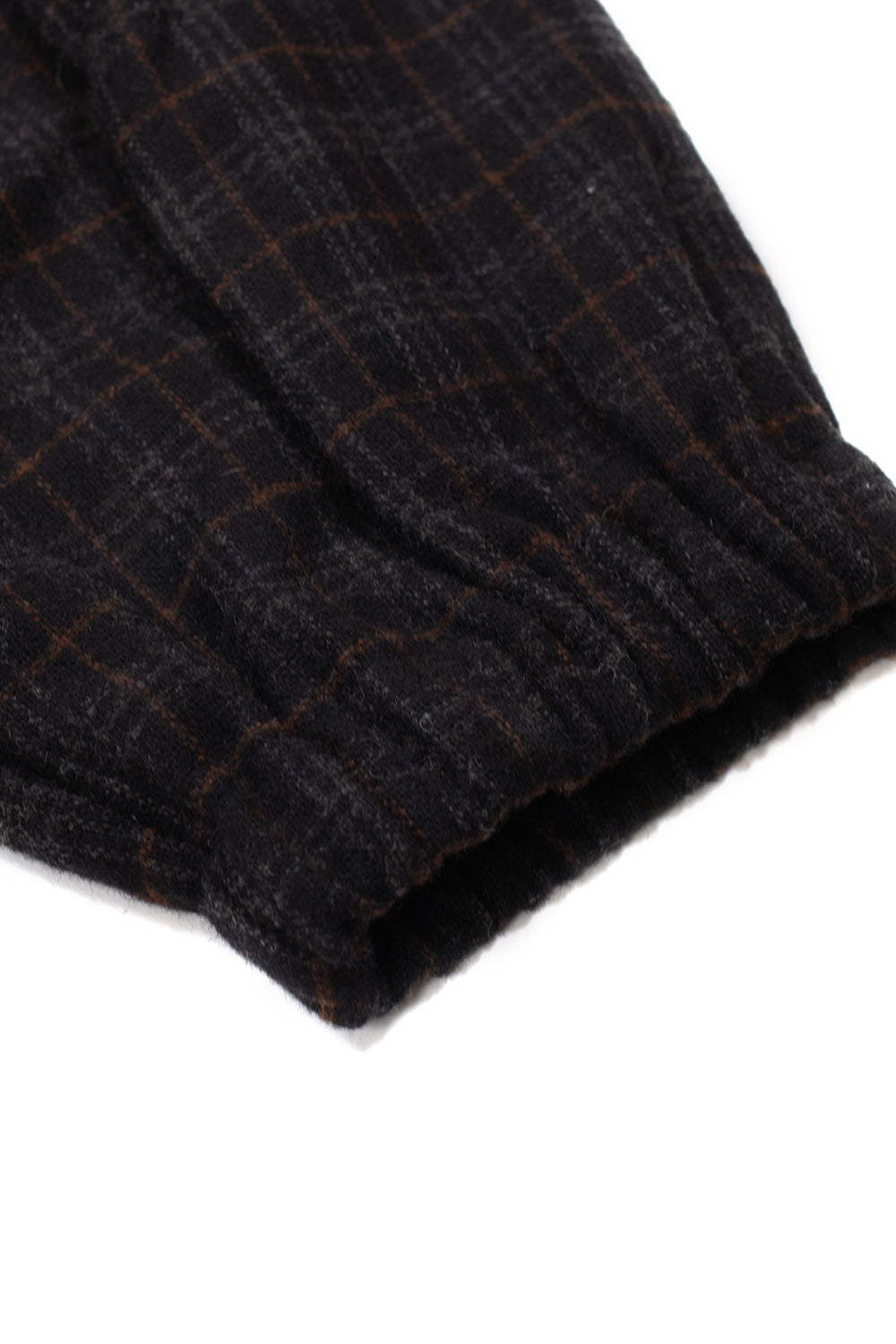 Macro close-up of the gathered elastic wrist cuff on the dark brown Umbro Flannel Fur Anorak, displaying the ruched fleece flannel fabric and clean hem finishing
