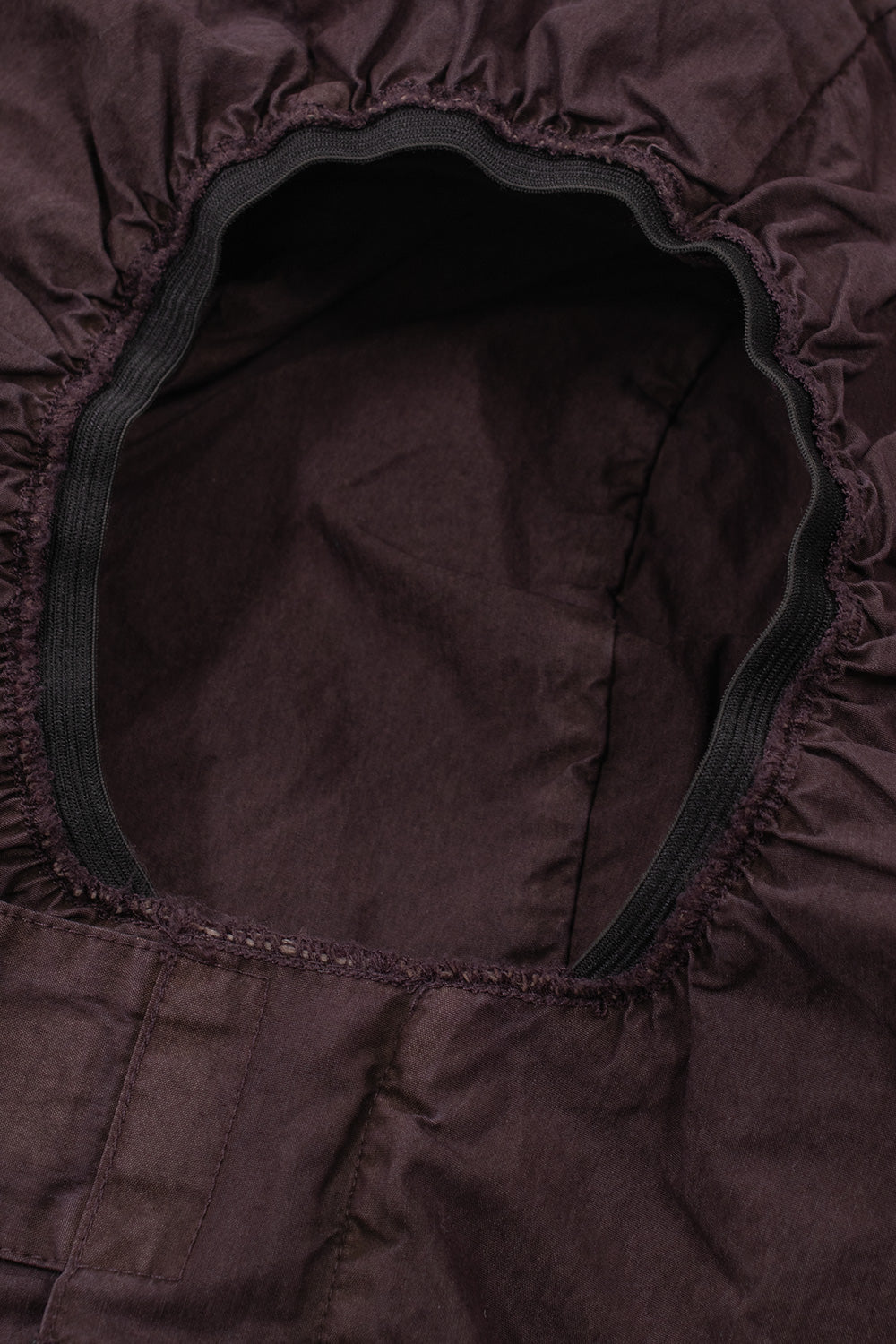 Interior view of the storm hood opening on the Umbro Midfield Jacket, displaying the stretchy gathered black elastic face rim designed for wind protection, clean inner lining seams, and the extended chin wrap panel