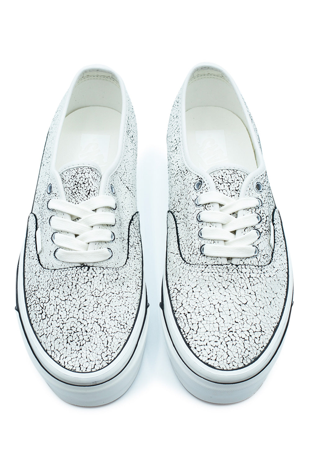 Top-down perspective of a pair of Vans LX Authentic 44 Overpaint sneakers, showing the intricate crackled paint texture over the toe box and eyestays, dark metal lace eyelets, white cotton laces, and clean white insoles.