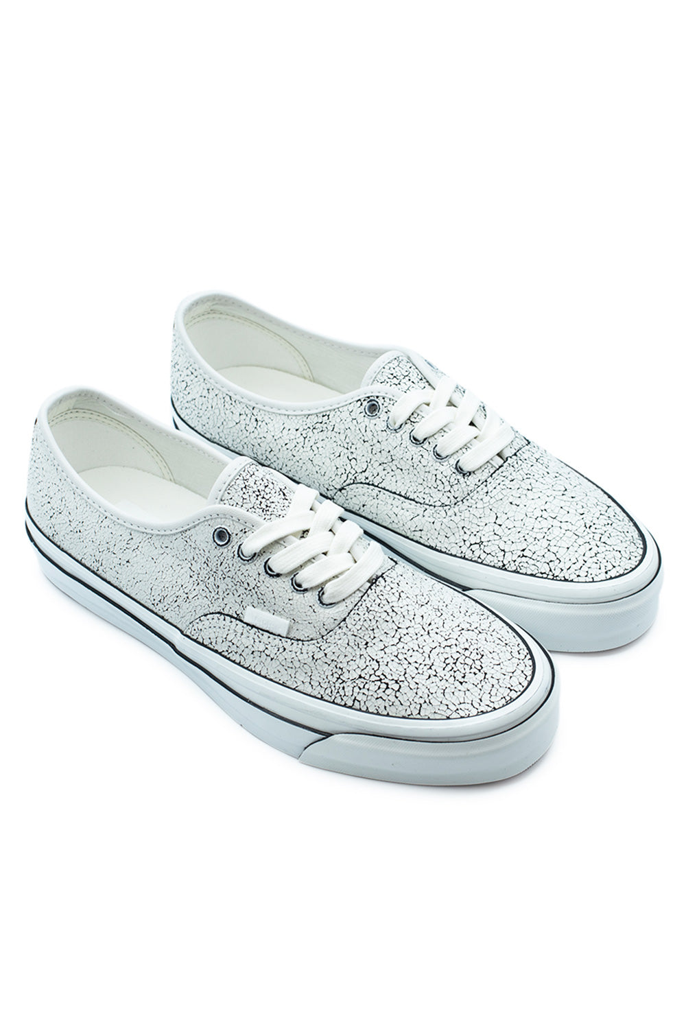 Three-quarter perspective studio shot of both Vans LX Authentic 44 Overpaint Blanc De Blanc shoes, showcasing the vintage 90s Osnaburg-inspired silhouette and the unique wear-away crackle paint detail across the upper.