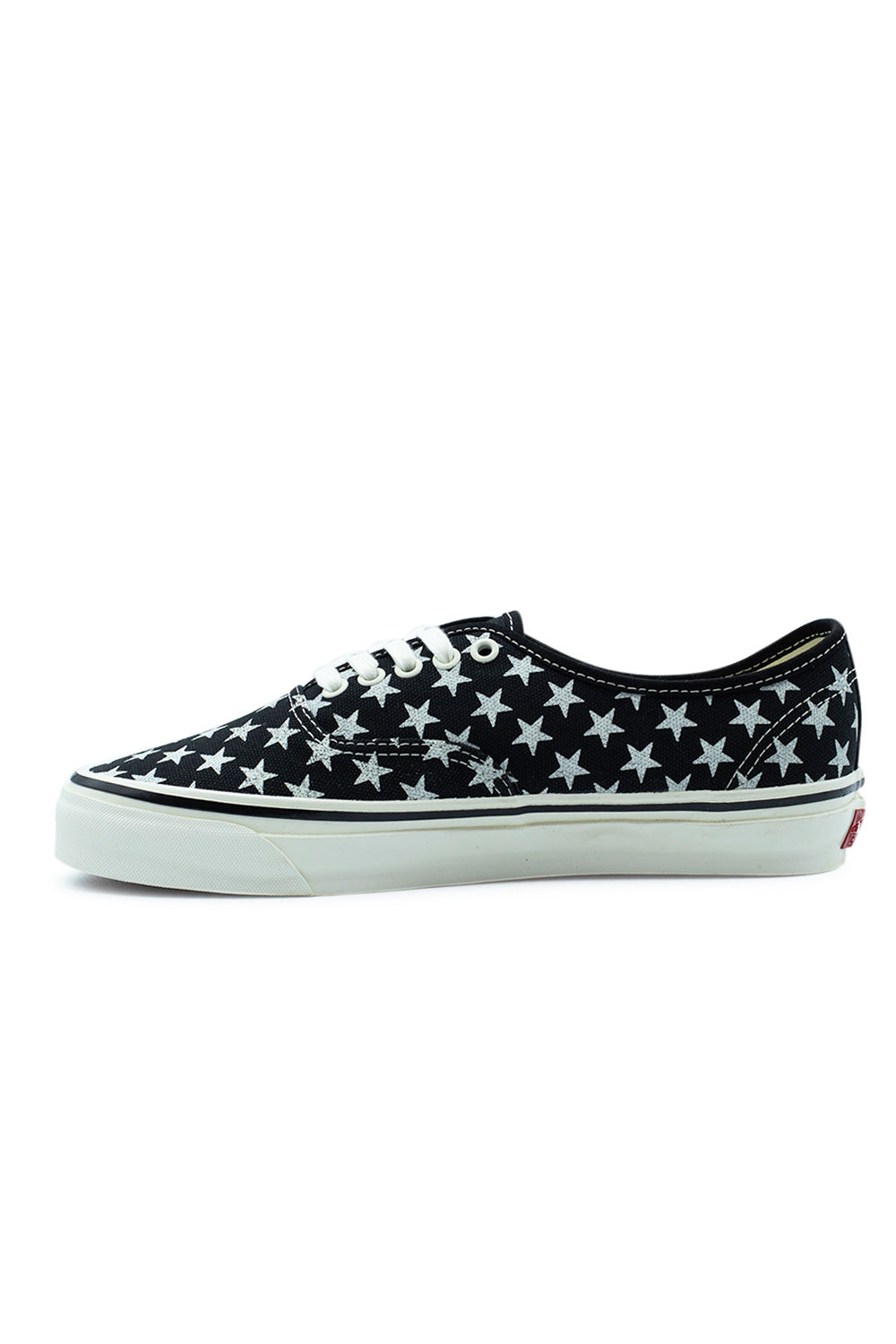 Medial side profile of the Vans LX Authentic 44 shoe, illustrating the continuous printed white star pattern across the black canvas upper, smooth white foxing tape, and clean vulcanized construction without a lateral woven tag.