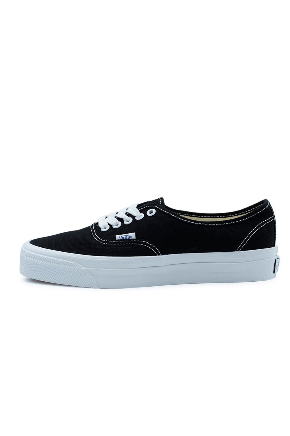 Side profile of the Vans LX Authentic Reissue 44 Shoe Black / White featuring a premium 226g black canvas upper, white rubber foxing with higher glossy sidewall, archival low-top silhouette, contrast stitching and the classic Vans waffle sole inspired by the original 1966 Style 44 skate shoe.