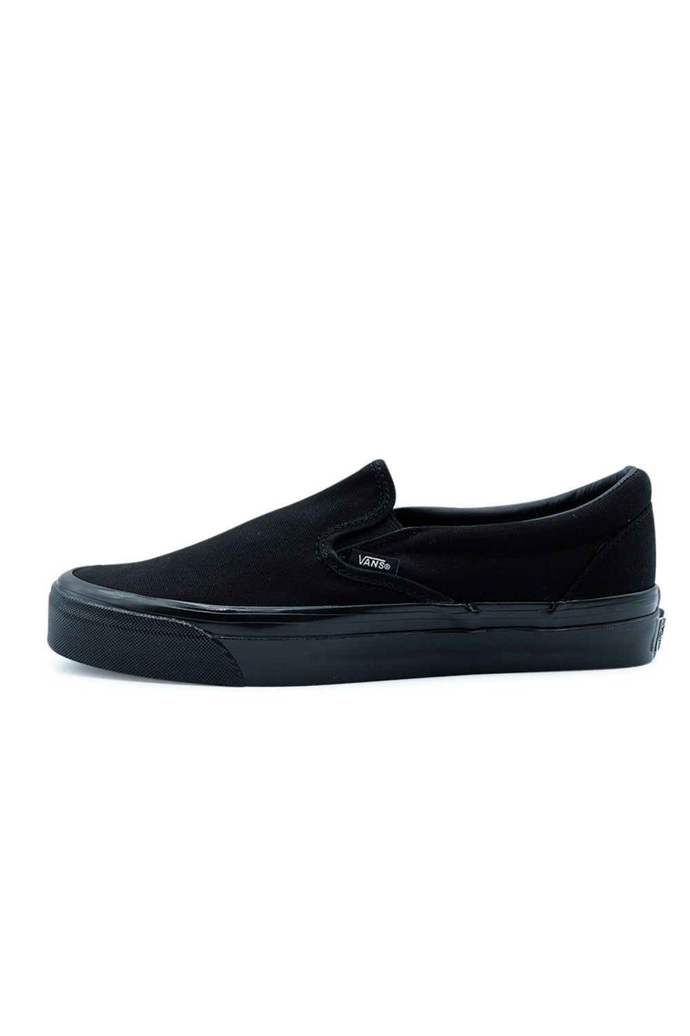Side profile of the Vans LX Slip-On Reissue 98 Shoe Black / Black featuring a monochrome triple black 226g canvas upper, archive-inspired low-top silhouette, glossy black foxing, premium Vans construction and timeless skateboarding slip-on design.