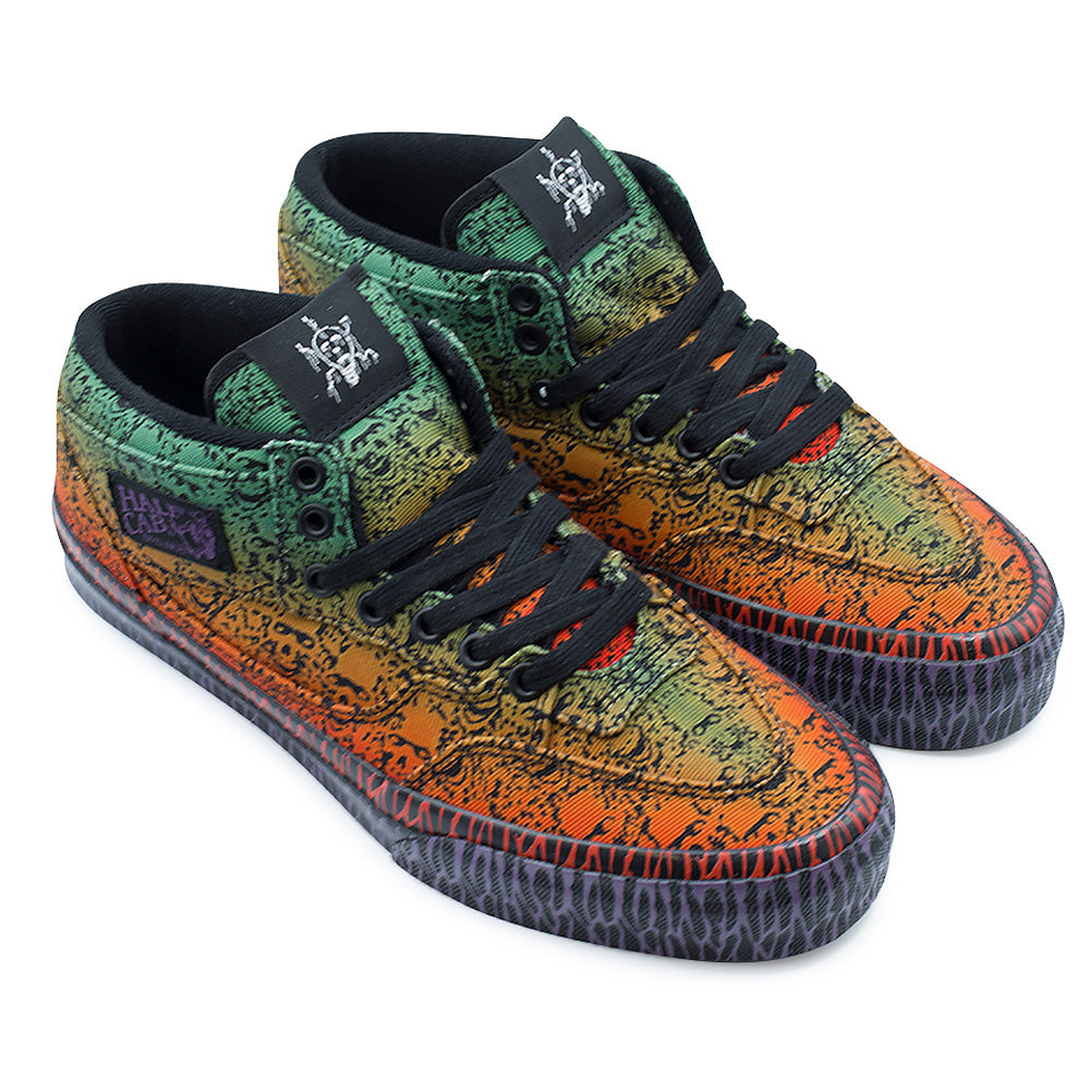 Three-quarter studio view of the Vans OTW x Chito Half Cab 33 sneakers, capturing the striking color transition from neon green at the ankles to burnt orange and red at the forefoot, covered in airbrushed Chito skull art, flat black laces, purple Half Cab side labels, and multi-colored tribal graphics on the black rubber foxing tape.