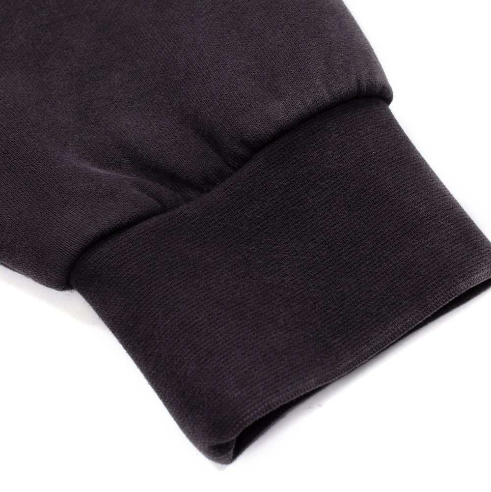 Macro studio view of the sleeve cuff on the Vans OTW x Chito Sweatshirt in black, displaying the dense elasticated rib knit construction and fine loopback French terry texture of the heavyweight dyed cotton fleece.