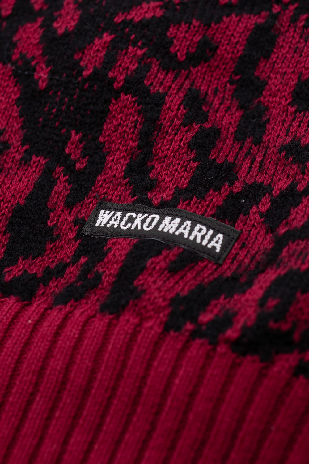 Wacko Maria side label and ribbed hem close up on red leopard cardigan, luxury cotton wool knit with signature Guilty Parties aesthetic made in Japan
