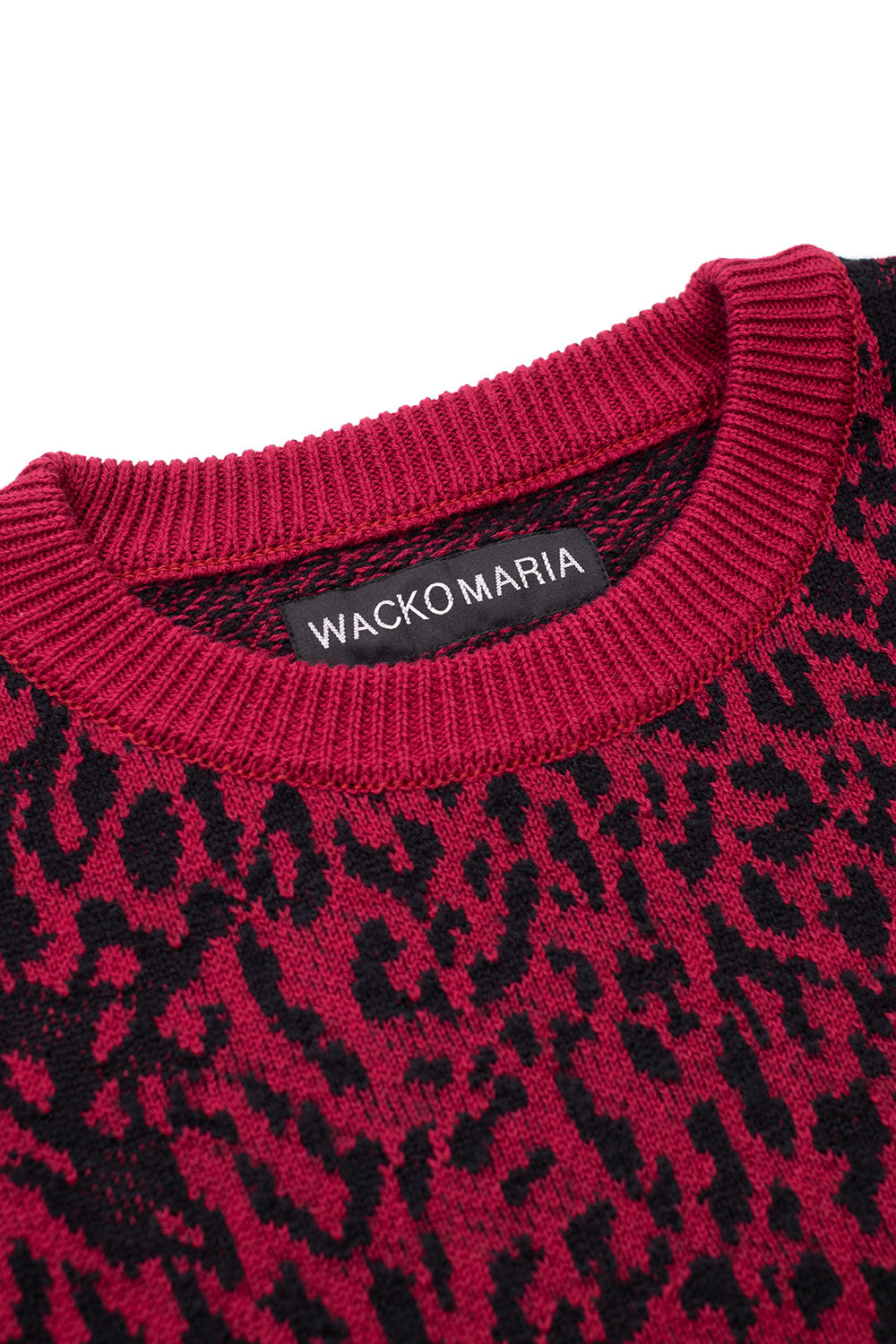 Close-up of Wacko Maria neckline label on red leopard jacquard sweater, ribbed crewneck collar detail, high-quality cotton wool knit, luxury Tokyo street fashion essential