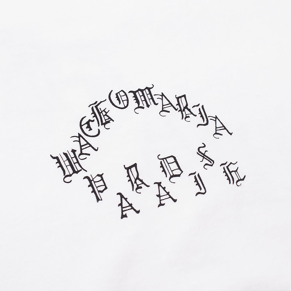 Macro perspective of the front chest graphic on the Wacko Maria Washed Heavy Weight T-Shirt, showing the curved three-tier black gothic Old English typography reading "WACKO MARIA PARADISE" printed onto crisp washed white cotton fabric.
