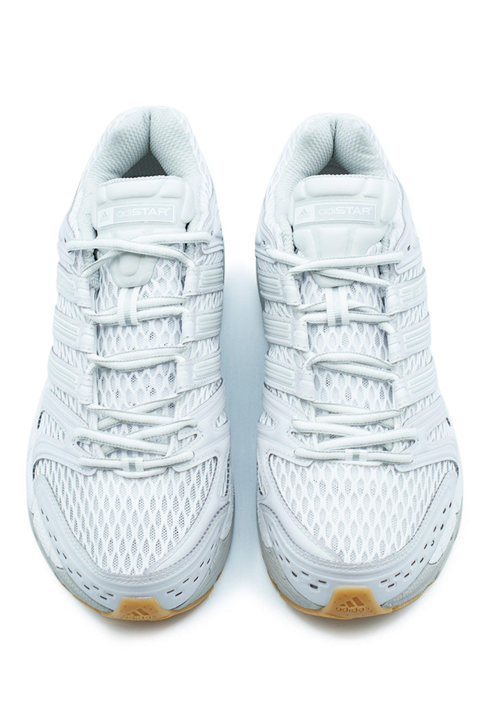 Top-down view of a pair of Adidas Adistar Control 5 shoes, highlighting the white athletic lacing system, breathable mesh tongue, and Adistar branding.