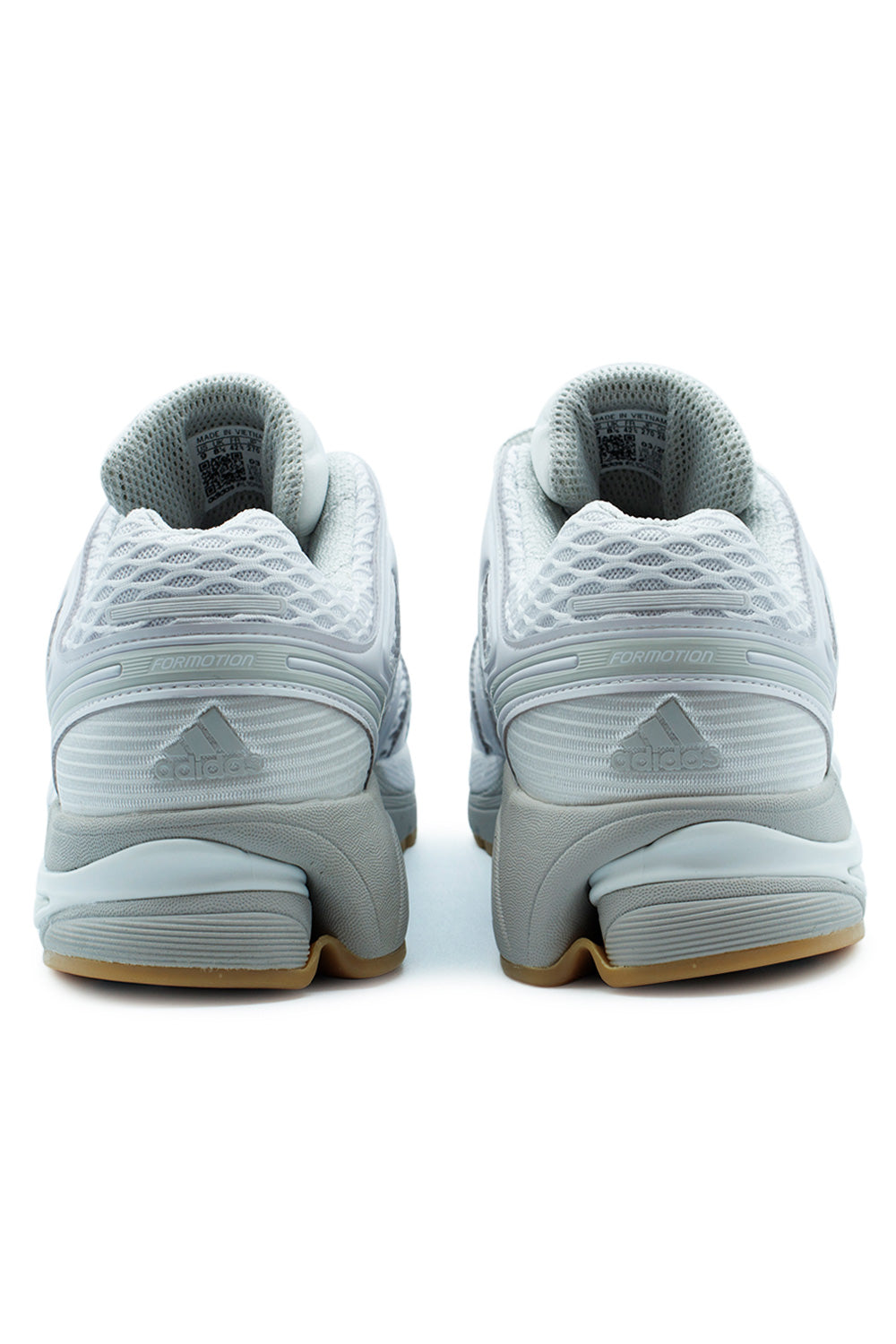 Rear heel view of the Adidas Adistar Control 5 sneakers, detailing the embossed grey Adidas logo, Formotion technology accents, and the old-school gum outsole.