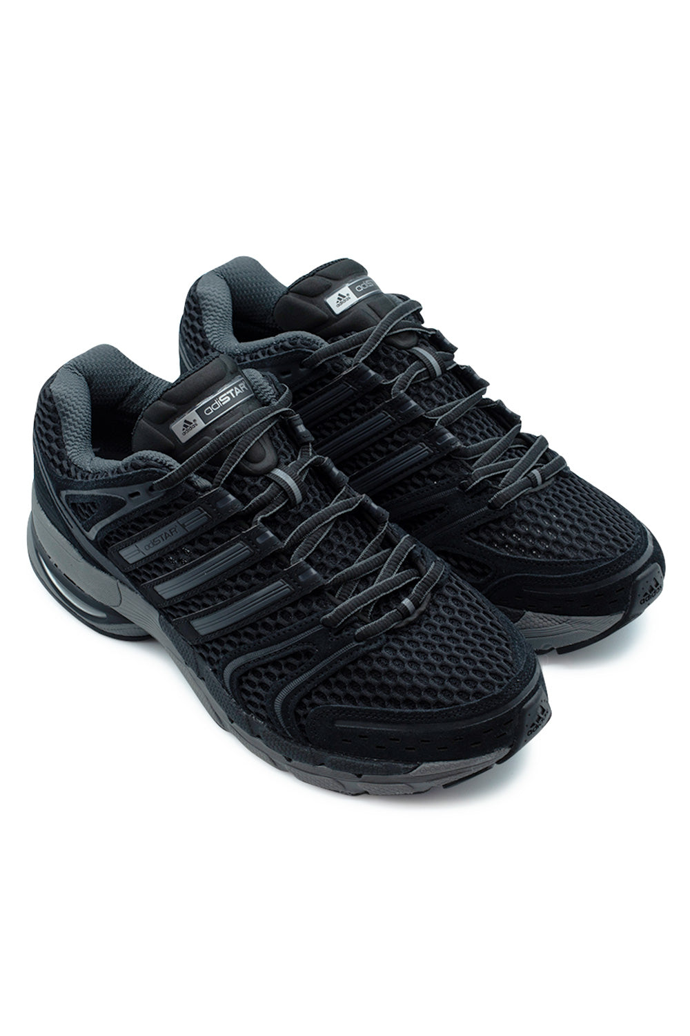 Three-quarter elevated studio view of the Adidas Adistar Control 5 technical runners in Core Black / Grey Six / Iron Metallic, showcasing the aggressive early 2000s Y2K running silhouette, sculpted cage overlays, and rugged road-ready outsole tread.