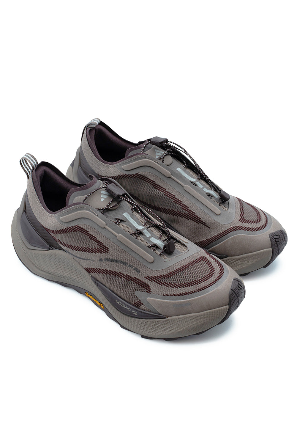 Three-quarter perspective studio shot of the Adidas Holo Peak sneakers in Trace Brown / Aurora Ruby / Maroon, illustrating the streamlined outdoor trail silhouette, thick shock-absorbing midsole, and bungee cord closure.