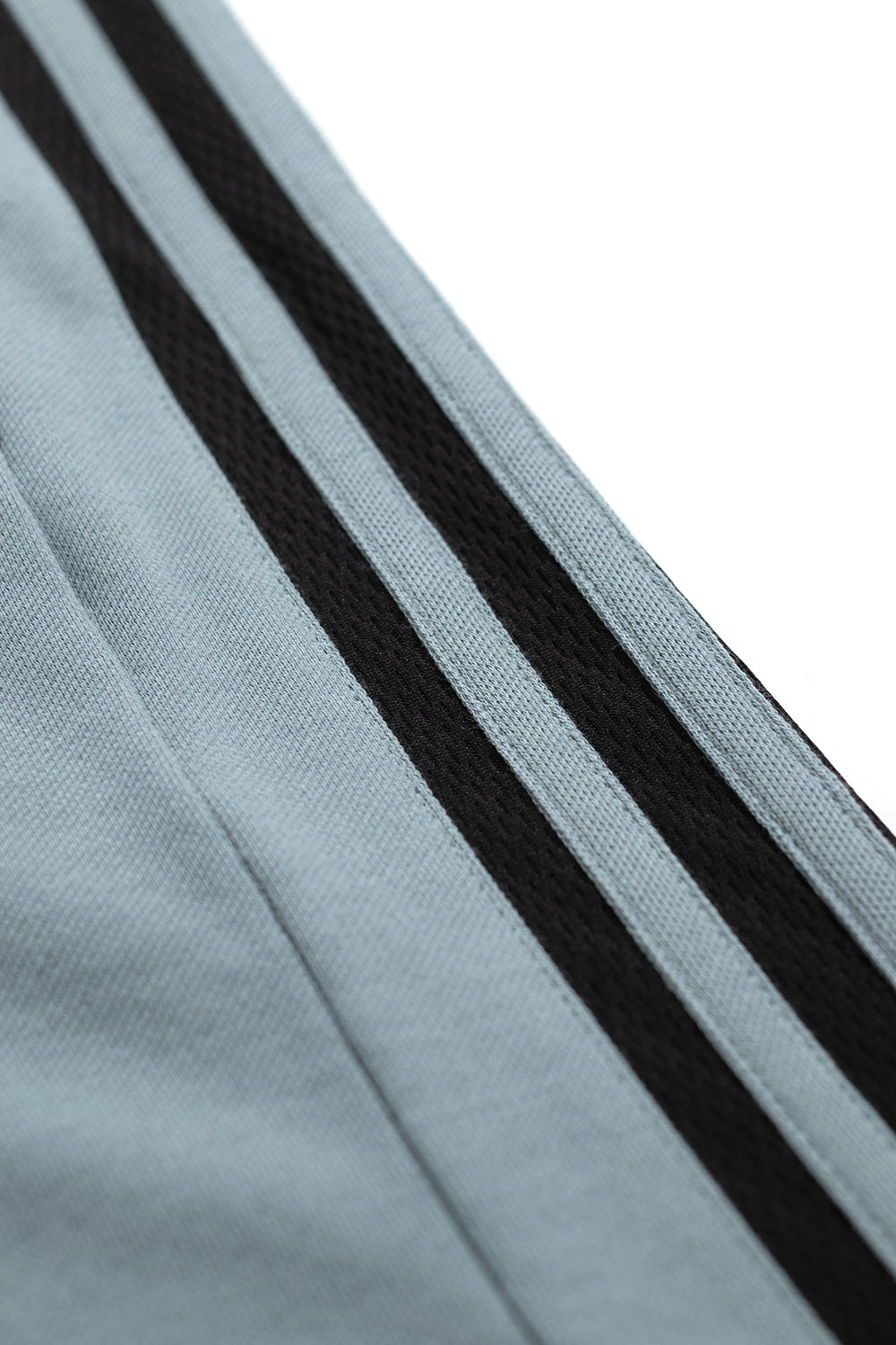 Close-up of adidas three-stripe sleeve design on Metalwood Studio polo Green Earth showcasing recycled performance fabric, loose fit cut and retro golf-inspired streetwear look