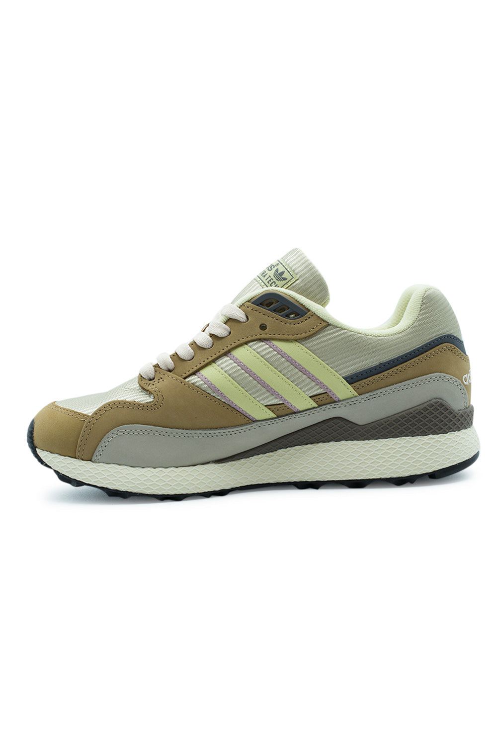 Medial arch profile view of the Adidas Oregon Ultra Tech shoe, detailing the inner side construction with smooth grey and tan nubuck mudguards, pastel yellow serrated three stripes, charcoal heel counter trim, and the diamond-grid Dellinger web cushioning unit extending across the arch