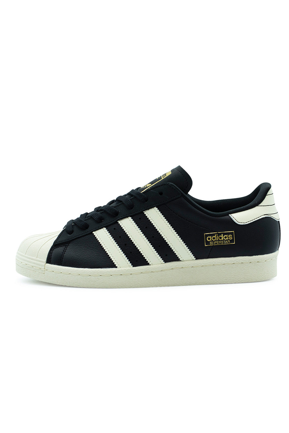 Lateral side profile view of the Adidas Skateboarding Superstar 80 ADV in Core Black / Cream White, featuring a black full-grain leather upper, cream white serrated leather 3-Stripes, gold metallic logo print, classic cream rubber shell toe, and stitched cold-cement cupsole.
