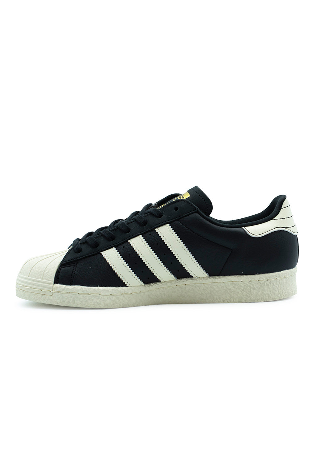 Medial side profile view of the Adidas Superstar 80 ADV shoe in Core Black, illustrating the clean inner full-grain leather construction, serrated cream white 3-Stripes, soft collar lining, and vulcanized-look cream rubber cupsole sidewall.