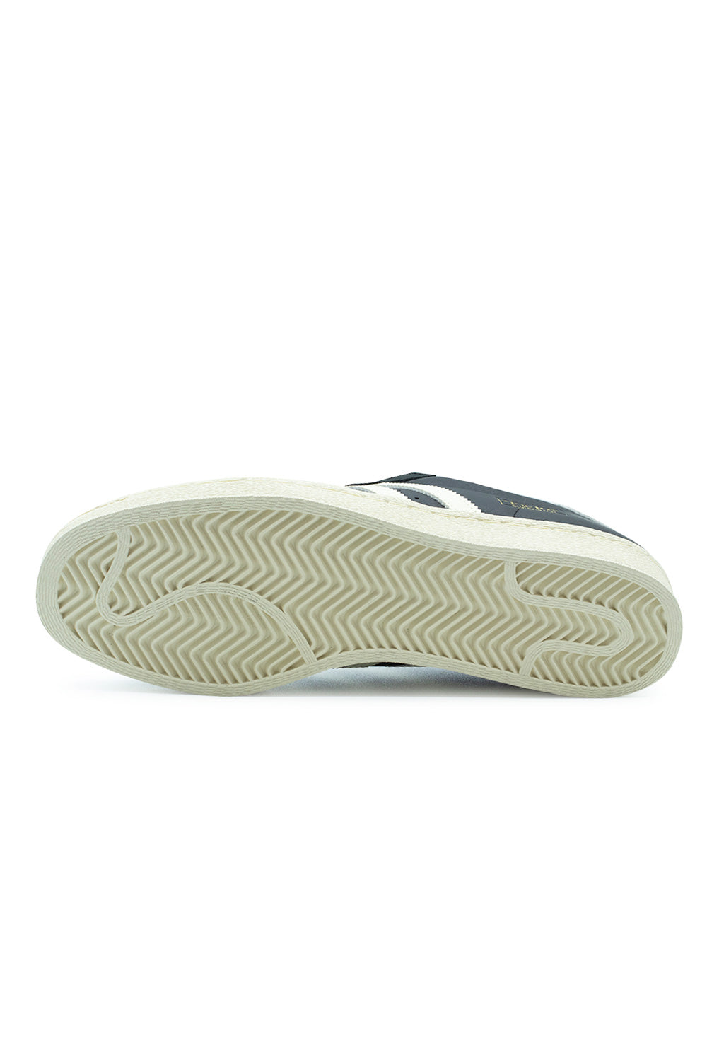Full bottom view of the cream white rubber cupsole on the Adidas Superstar 80 ADV skate shoe, displaying the traditional herringbone tread pattern engineered for multidirectional board grip and traction.
