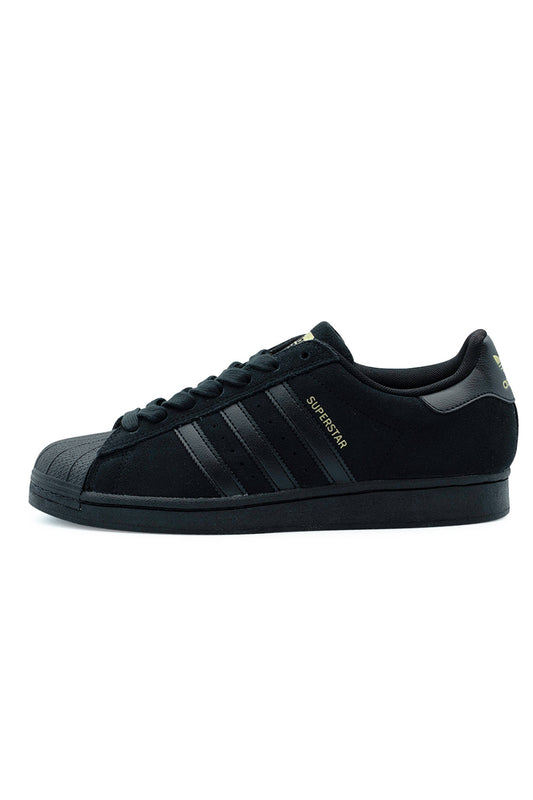 Lateral side profile view of the all-black Adidas Skateboarding Superstar ADV shoe, featuring a premium black suede upper, tonal leather 3-Stripes, metallic gold foil Superstar lettering, a textured black rubber shell toe cap, and a matching stitched cupsole.