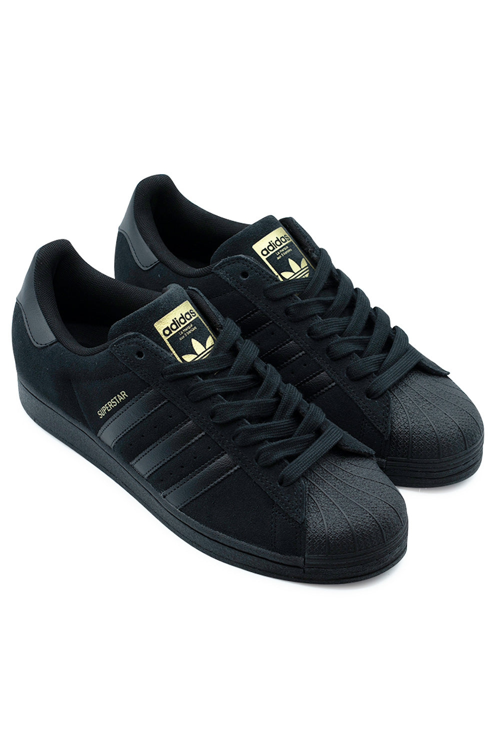 Three-quarter perspective studio shot of the Adidas Superstar ADV shoes in Core Black and Gold Metallic, showcasing the reinforced suede skate construction, abrasion-resistant shell toe, and sleek triple black finish.