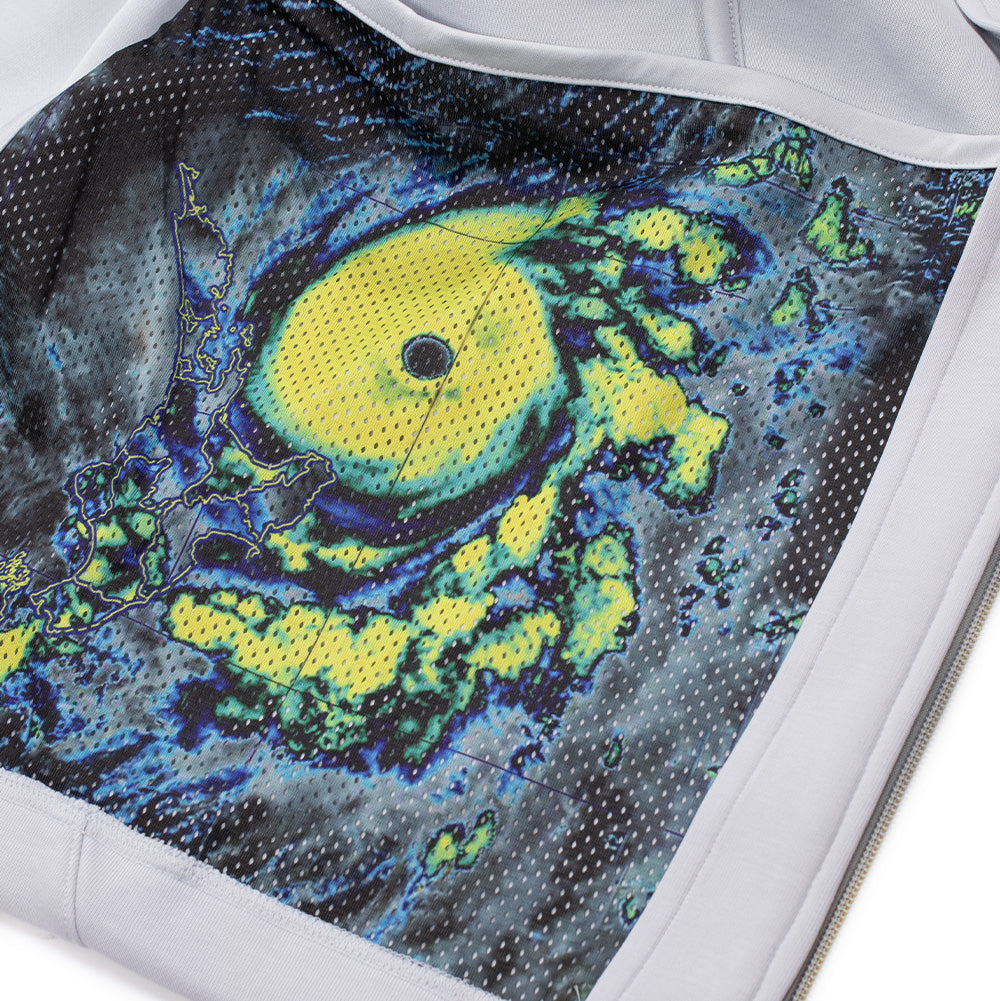 Macro studio close-up of the interior pocket pouch on the adidas x ADWYSD Full Zip Hoodie, highlighting the breathable white eyelet mesh lining printed with a high-saturation multi-colored meteorological weather satellite map depicting a tropical storm radar image.