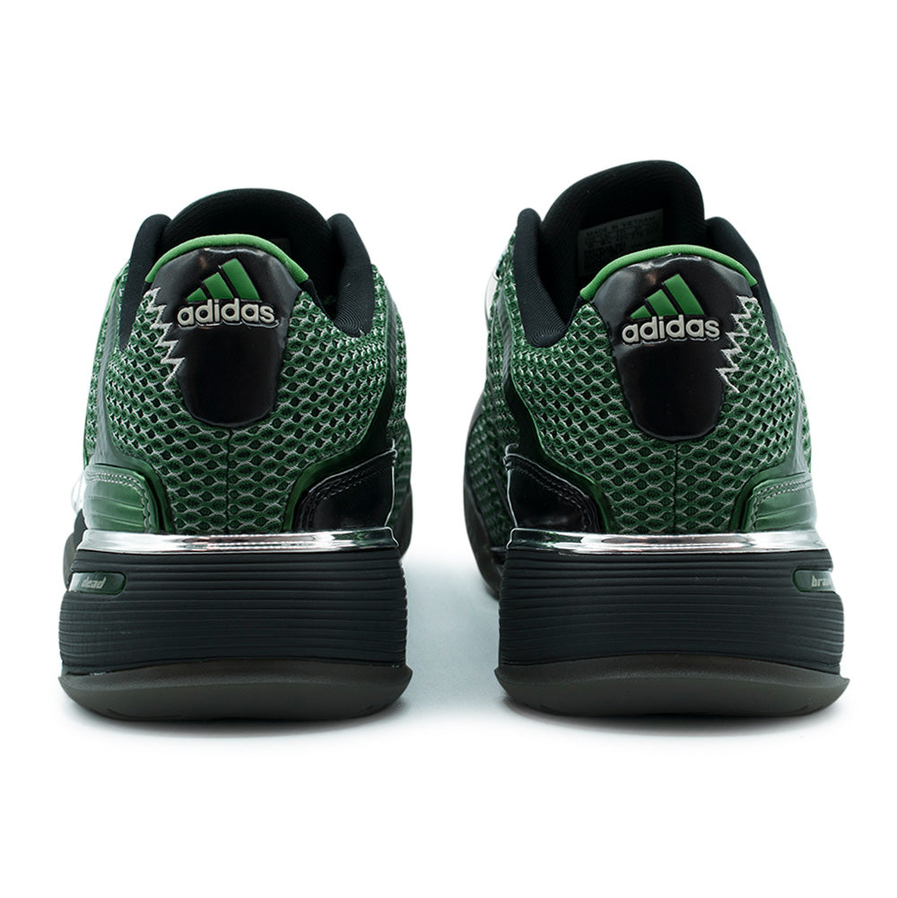 Rear studio view of the adidas x Brain Dead Barricade V heels, displaying the layered open-hole mesh collars, glossy patent leather heel counters, bright green embroidered adidas Performance triangle logos, mirror-finish silver metallic midsole shanks, and embossed branding across the textured carbon outsoles.