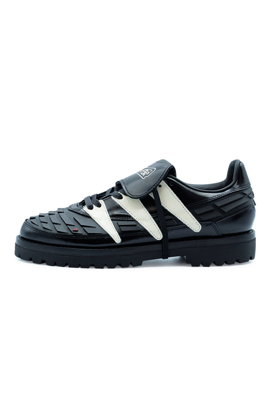 Side profile of the Adidas Originals x Brain Dead x Disney Predator sneaker in Core Black / Crystal White / Core Black, featuring premium leather construction, iconic Predator 94 rubber strike fins, oversized lug outsole, removable fold-over tongue and exclusive retro football inspired collaboration.