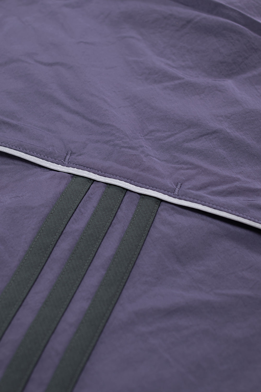 Fabric texture detail of Adidas x Metalwood purple pullover showing durable polyamide shell, recycled polyester lining, and premium athletic street fashion finish.