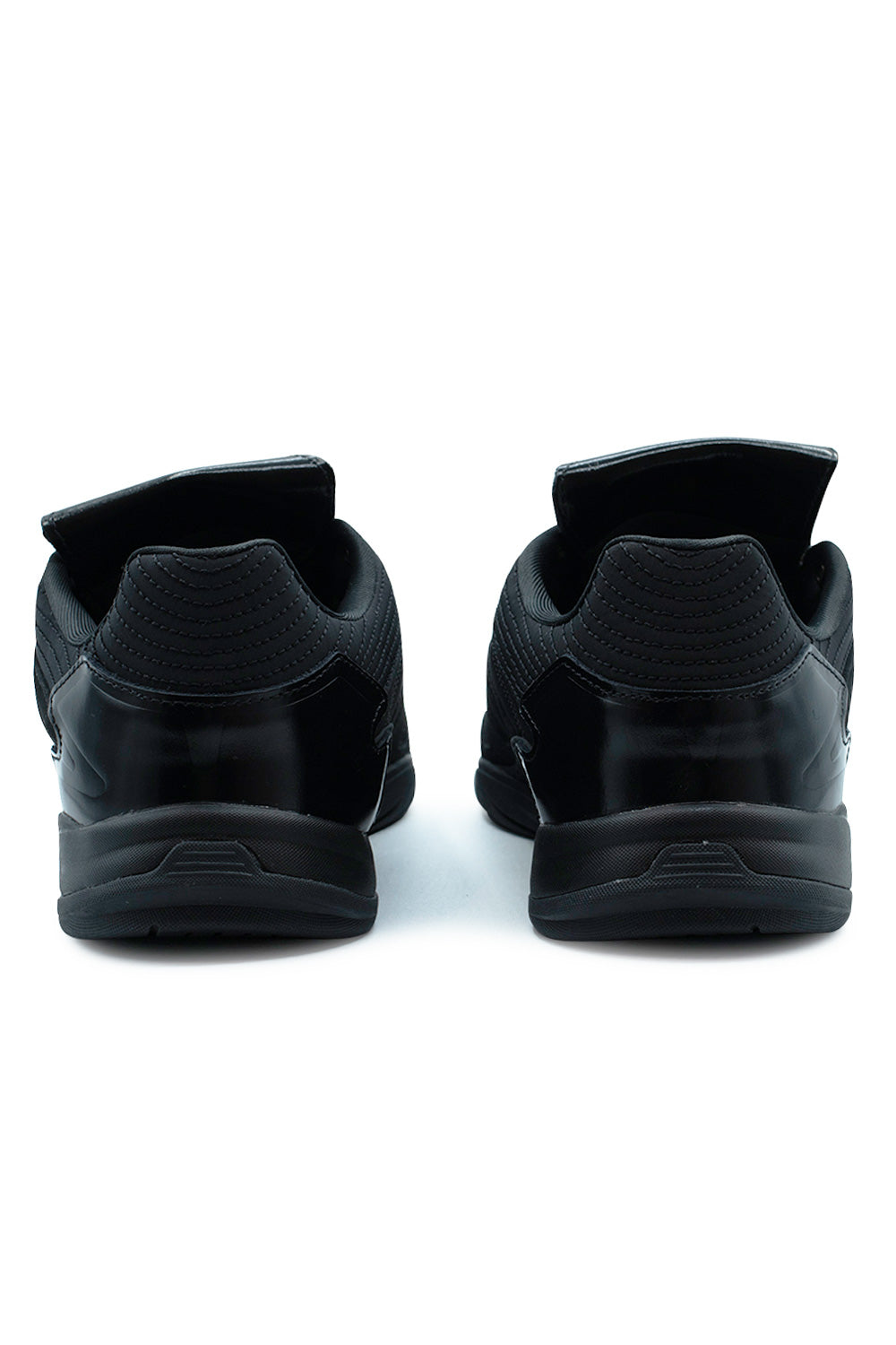 Rear view of the heels of the Adidas X Metalwood Studio Predator Sala shoes, highlighting the glossy black external heel counters, quilted padded textile collar mesh, and solid black rubber sole bases.