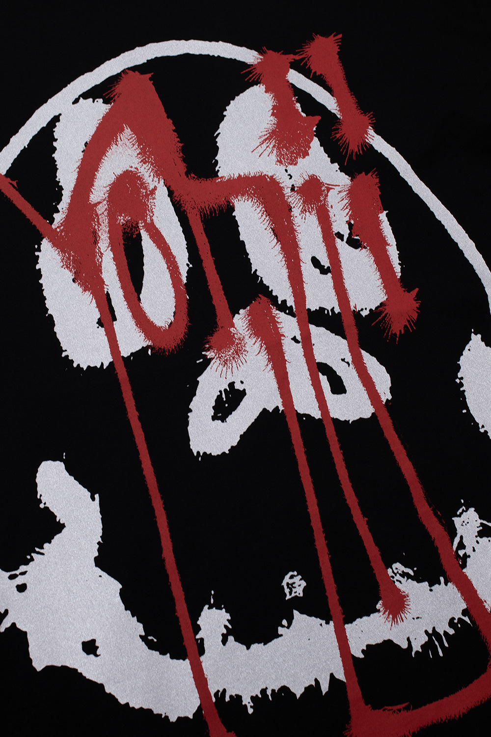 Macro detail shot of the chest print on the black Adidas Y-3 X Chito Skull Graphic Short Sleeve Tee, showing the high-contrast white airbrushed skull graphic overlaid with a dripping red spray paint Yohji signature tag.