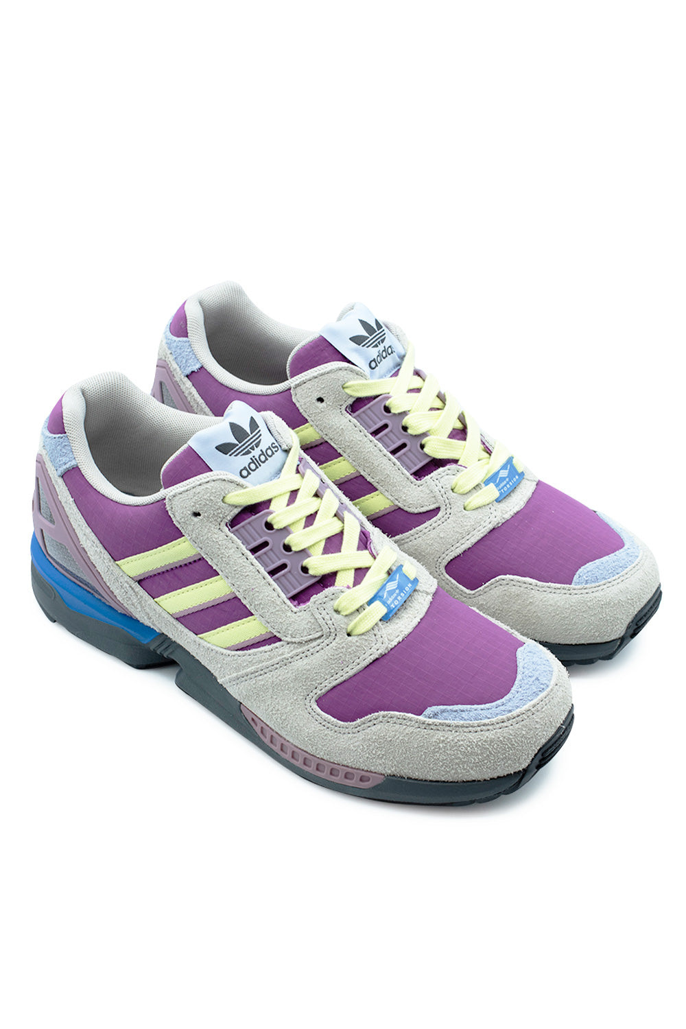 Elevated three-quarter perspective of the Adidas ZX 8000 in Lucky Pink, Yellow Tint, and Grey Six, emphasizing the layered multi-material runner construction, contrast between hairy suede and durable ripstop, and heritage late-eighties running shoe silhouette.