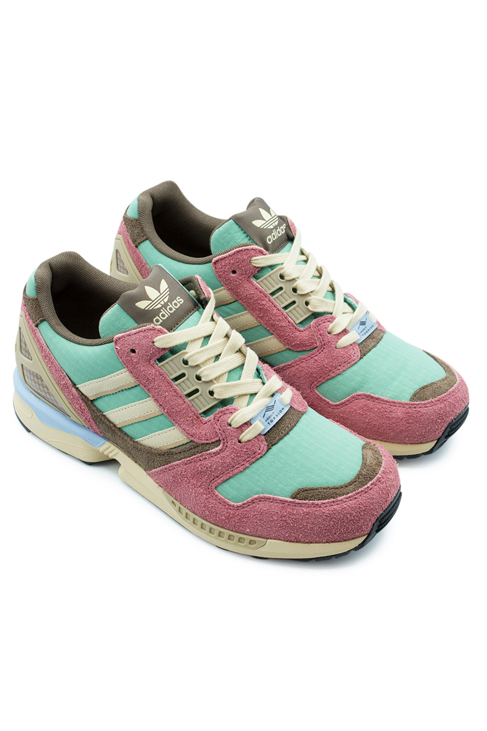 Elevated three-quarter studio perspective of the Adidas ZX 8000 in St Fade Ocean / Sand Strata / Wonder Red, capturing the archival late-eighties marathon runner aesthetic, multi-layered pastel and earthy panels, hairy suede overlays, and iconic retro running silhouette