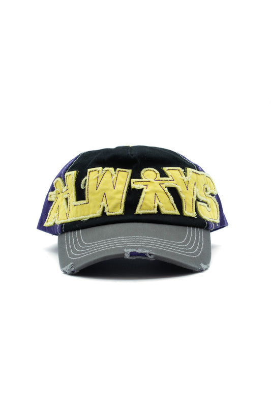 Front studio view of the Always Do What You Should Do Human Logo 5 Panel Cap, featuring a black front panel, purple side panels, a distressed grey curved visor with torn fabric details, and oversized yellow raw-edge frayed twill letter patches spelling out "ALWAYS" with the signature human silhouette integrated into the letters.