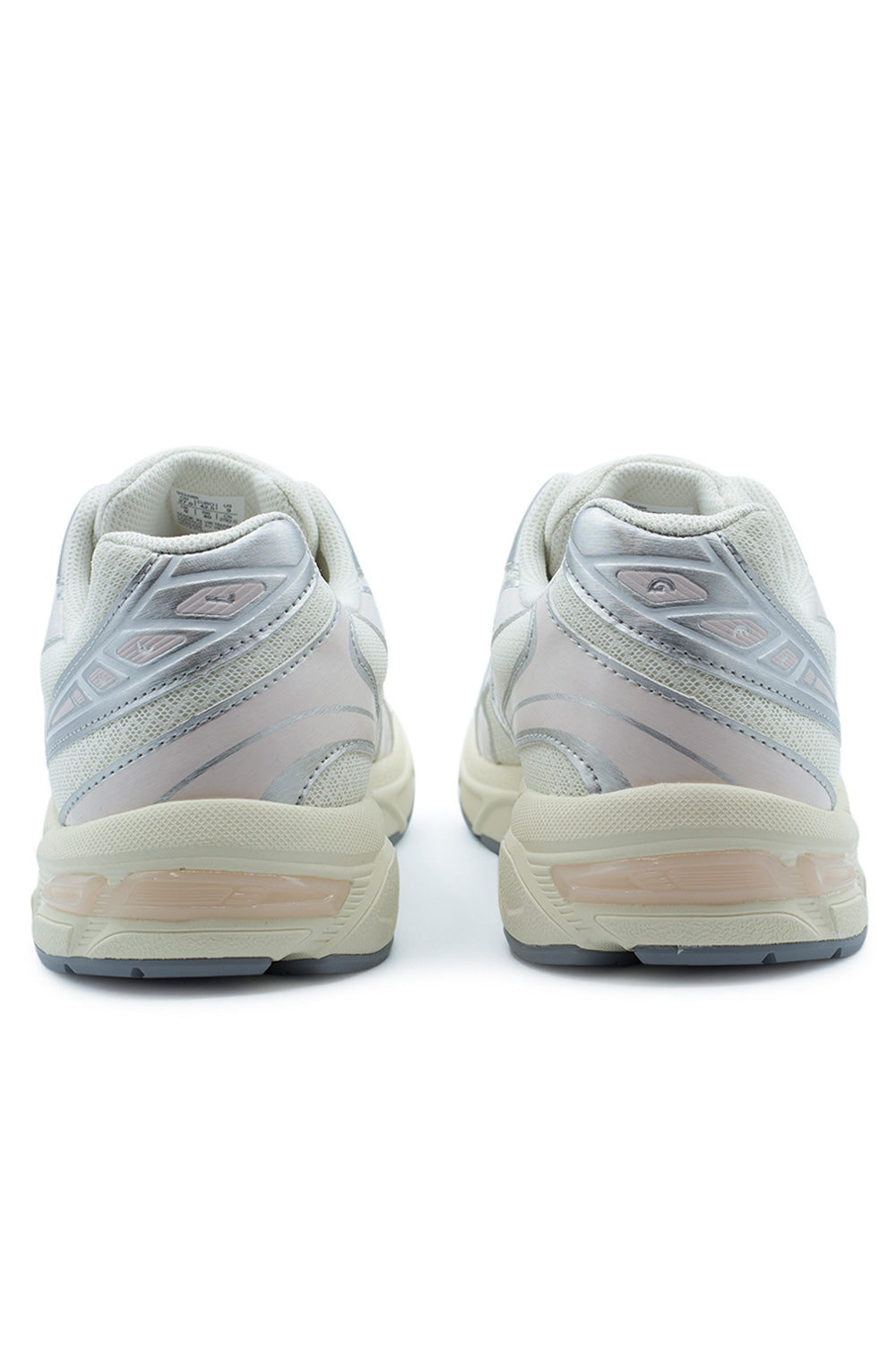 Rear view of the heels of the Asics Gel-1130 sneakers, displaying the padded off-white textile collars, pearlescent silver synthetic heel panels with subtle Pink Cloud accents, embossed swirl graphics, and cream foam midsole with visible pink-tinted GEL cushioning units.
