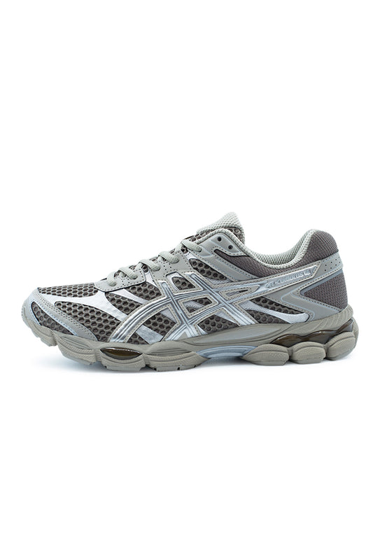 Lateral profile view of the Asics Gel-Cumulus 16 running sneaker in Cocoa Powder and Pure Silver, showcasing the open honeycomb dark cocoa brown mesh upper, metallic silver synthetic leather overlays, iconic silver tiger stripes, two-tone grey FLUIDRIDE foam midsole with visible rearfoot and forefoot GEL cushioning capsules, and "GEL-CUMULUS 16" lettering along the lateral heel.