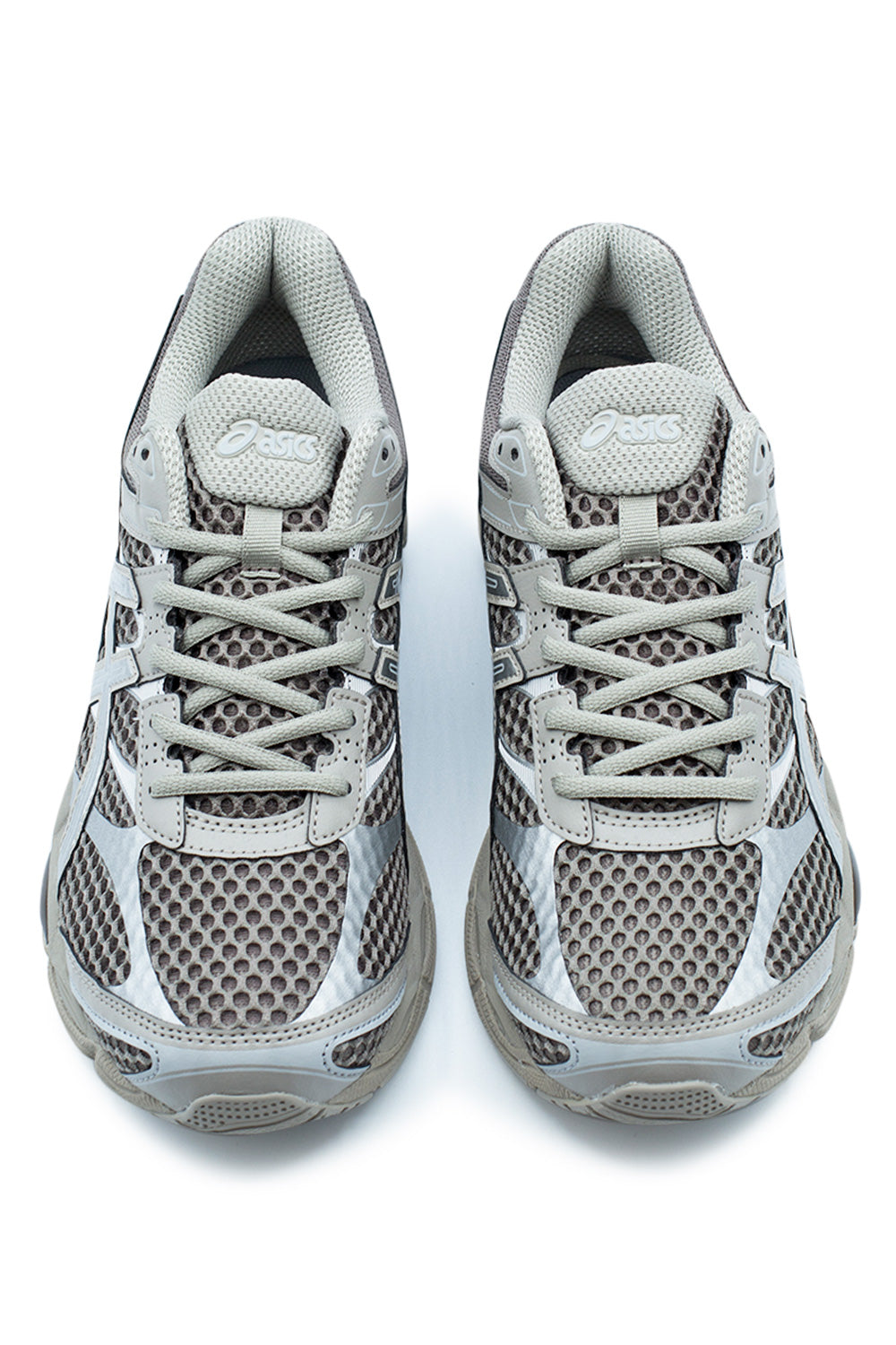 Top-down studio shot of a pair of Asics Gel-Cumulus 16 sneakers, highlighting the breathable wide-gauge Cocoa Powder mesh toe boxes, textured metallic silver toe caps, grey flat athletic laces laced through reinforced synthetic eyelet stays, and padded mesh tongue with silver oval Asics branding.