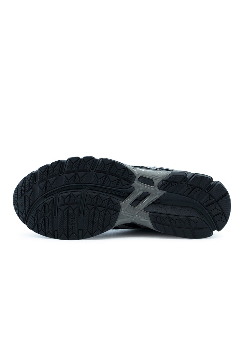 Full bottom view of the black rubber outsole on the Asics Gel-Kayano 20, displaying the multi-directional herringbone and grooved traction pods, the central longitudinal Guidance Line decoupling groove, and the semi-translucent smoky GUIDANCE TRUSSTIC stability bridge across the midfoot.