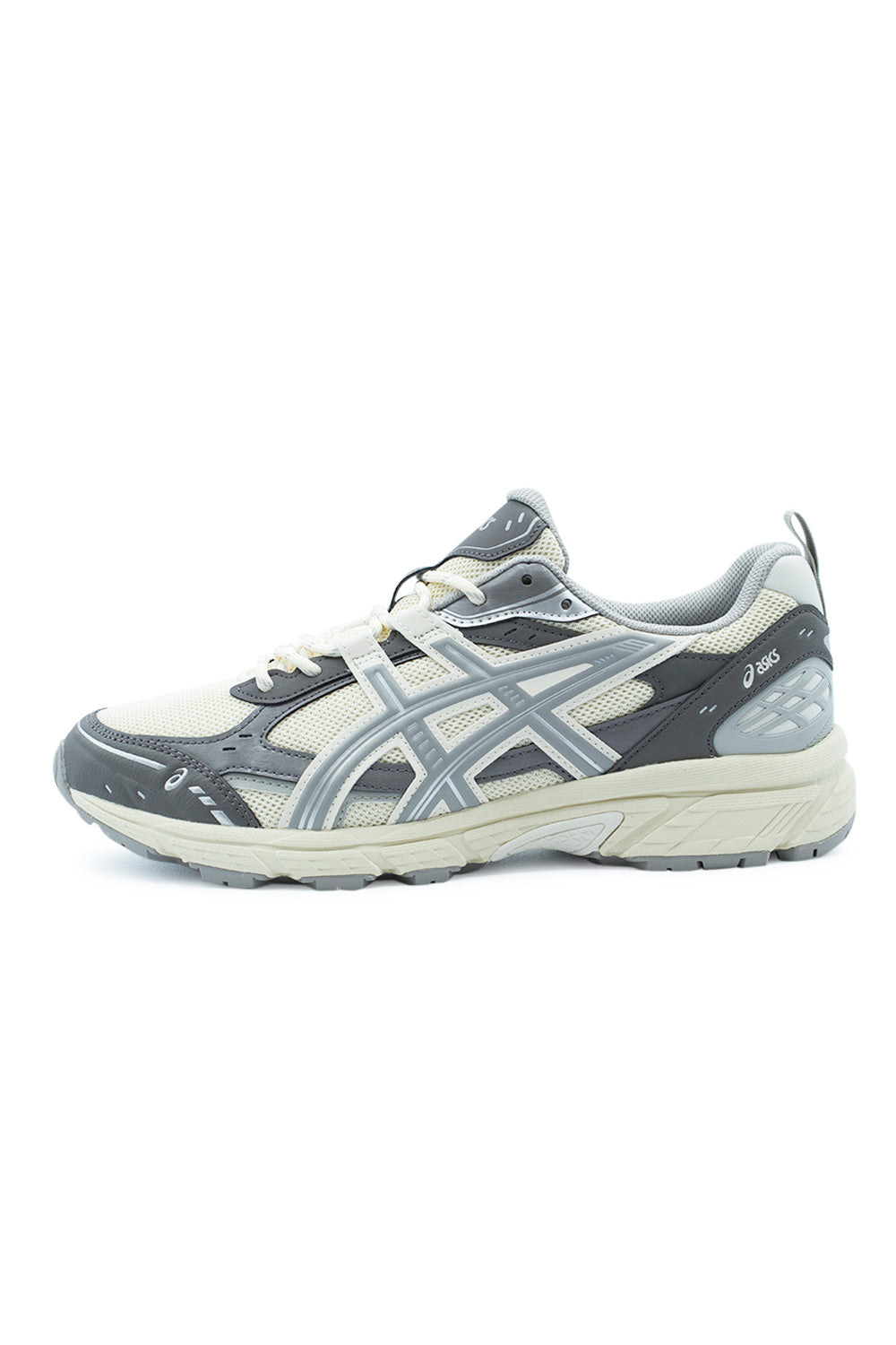 Lateral side view of the Asics Gel-Nunobiki sneaker in Cream and Cement Grey, showing the warm cream fine-pore mesh underlay reinforced with dark cement grey synthetic mudguards, matte cream tiger stripes, cushioned foam midsole, and rugged grey trail lugs along the outsole.