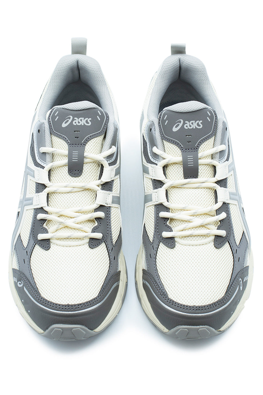 Top-down shot of a pair of Asics Gel-Nunobiki shoes, displaying the breathable cream mesh toe boxes, grey synthetic toe cap guards, two-tone speckled cord laces, and padded mesh tongue with an embossed white Asics spiral logo badge.