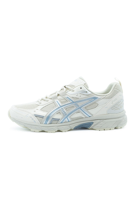 Lateral profile view of the Asics Gel-Nunobiki trail sneaker in light Smoke Grey and Slate Blue, featuring an off-white open-mesh upper, tonal cream synthetic leather overlays, pastel slate-blue tiger stripe outlines, a lightweight foam midsole with rearfoot GEL cushioning, and a trail-ready lugged rubber outsole.