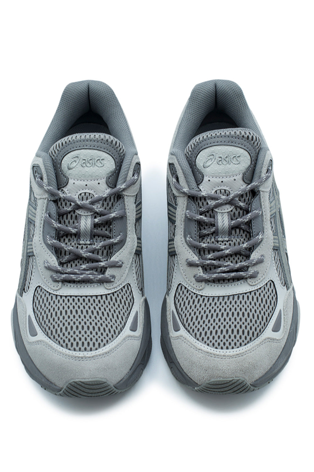 Top-down studio view of a pair of Asics Gel-NYC 2.0 sneakers, highlighting the open-hole mesh toe box, soft grey suede toe cap overlays with reflective cutouts, two-tone speckled rope laces, and textured padded tongues embroidered with the tonal Asics spiral logo.